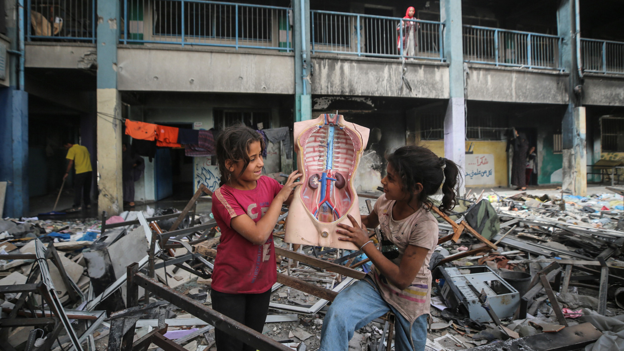 Displaced Palestinian children play inside a school that lies in ruins after Israeli attacks in Khan Yunis on 11 May 2024 (Majdi Fathi/NurPhoto via Reuters)