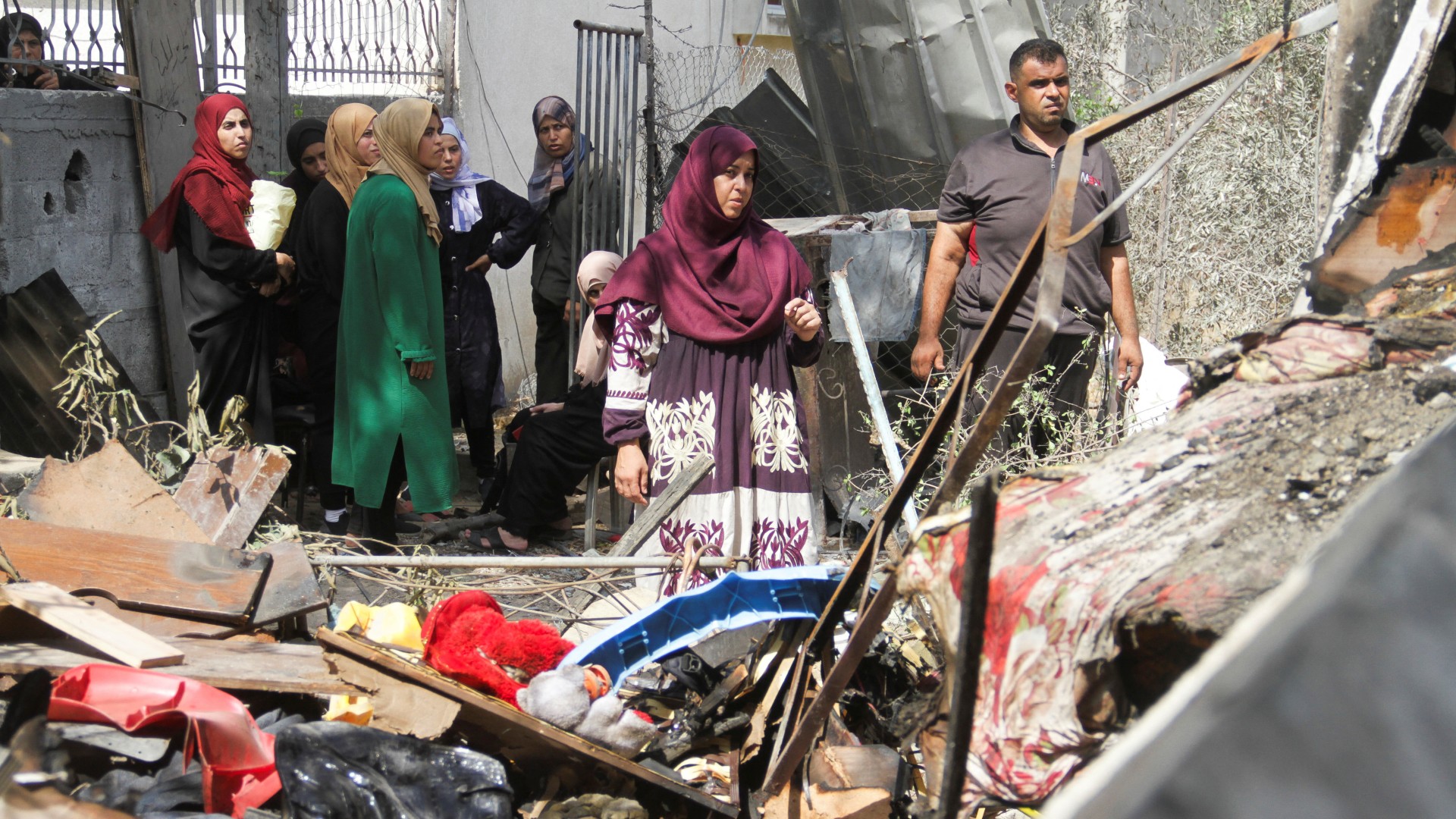 Palestinians stand at the site of an Israeli strike on a house, amid the Israel-Hamas conflict, in Beit Lahia in the northern Gaza Strip, August 22, 2024. REUTERS/Mahmoud Issa