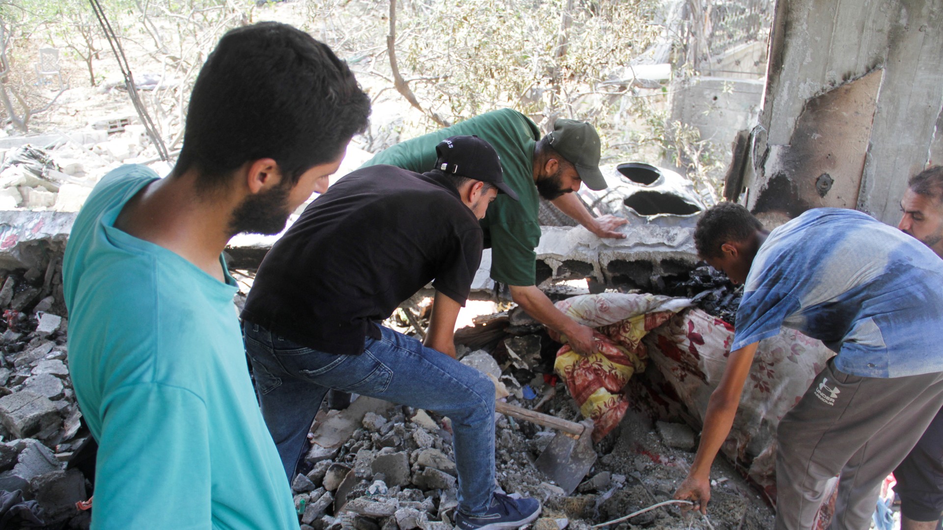 Palestinians clear rubble at the site of an Israeli strike on a house, amid the Israel-Hamas conflict, in Beit Lahia in the northern Gaza Strip, August 22, 2024. REUTERS/Mahmoud Issa