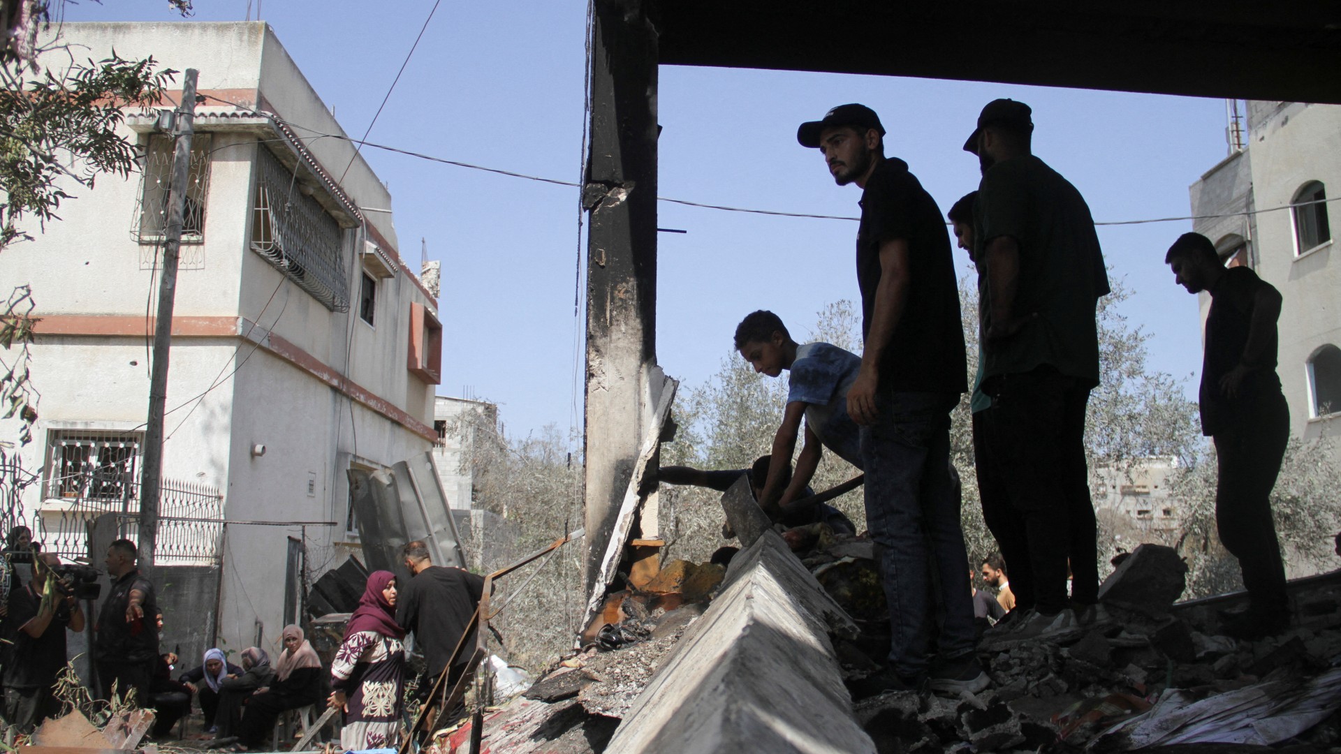 Palestinians stand at the site of an Israeli strike on a house, amid the Israel-Hamas conflict, in Beit Lahia in the northern Gaza Strip, August 22, 2024. REUTERS/Mahmoud Issa TPX IMAGES OF THE DAY