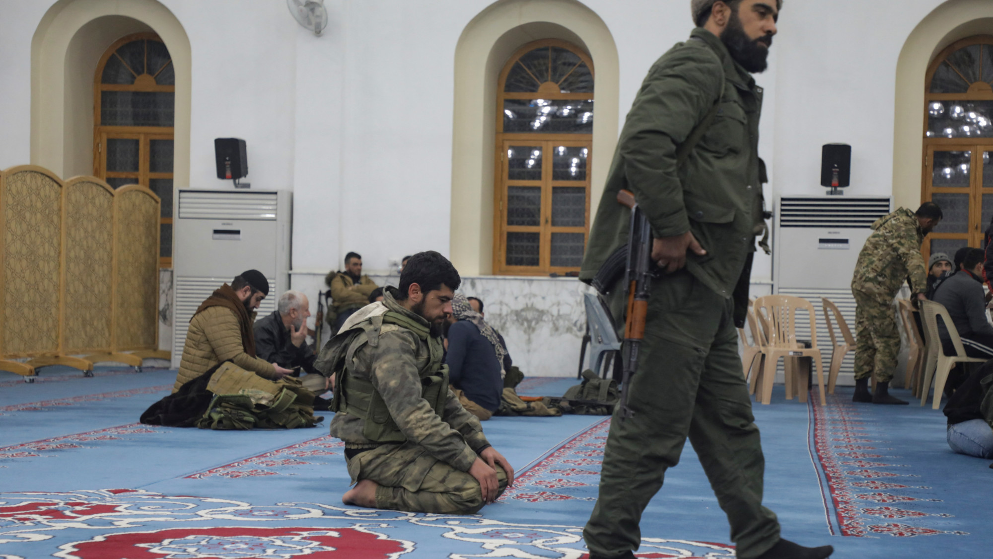 A rebel fighter prays in a mosque in Homs after on 8 December 2024 (Reuters/Mahmoud Hasano)
