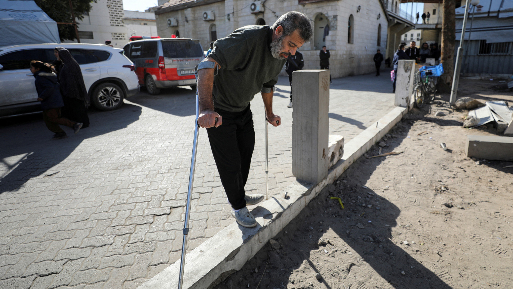 A Palestinian forcibly evacuated from Kamal Adwan hospital walks with crutches in Gaza City, on 28 December 2024 (Reuters/Dawoud Abu Alkas)