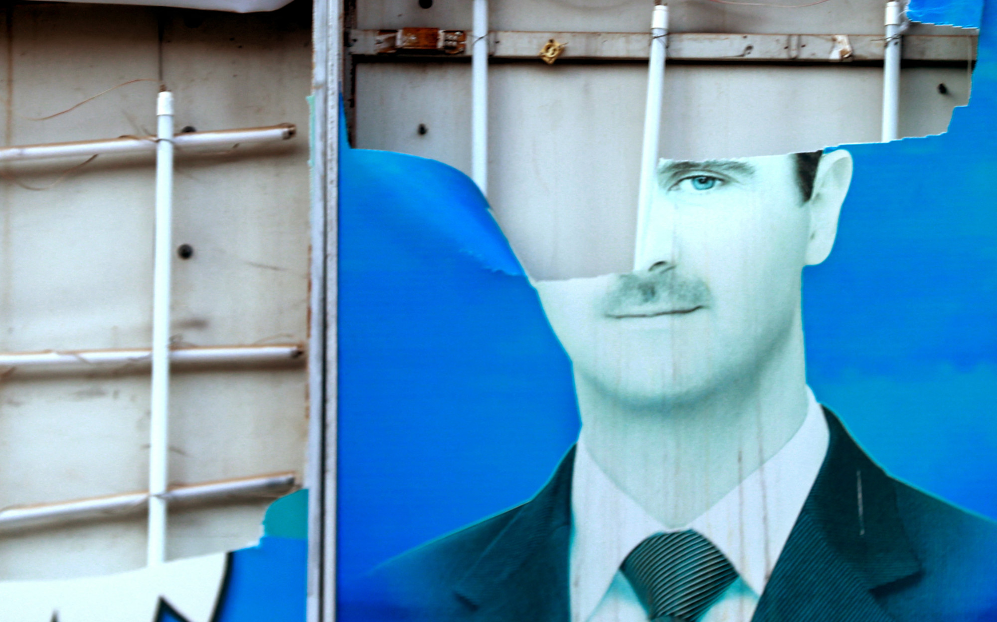 A torn picture of Bashar al-Assad in Qamishli (AFP)