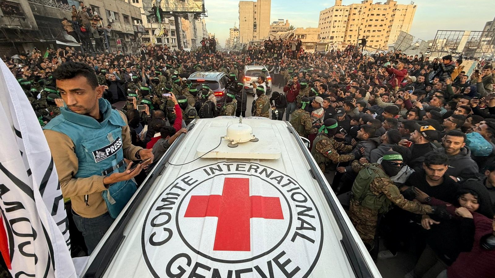 Hamas surround Red Cross vehicles who have entered the heart of Gaza City to retrieve three Israeli captives (Dawoud Abu Aklas/Reuters)