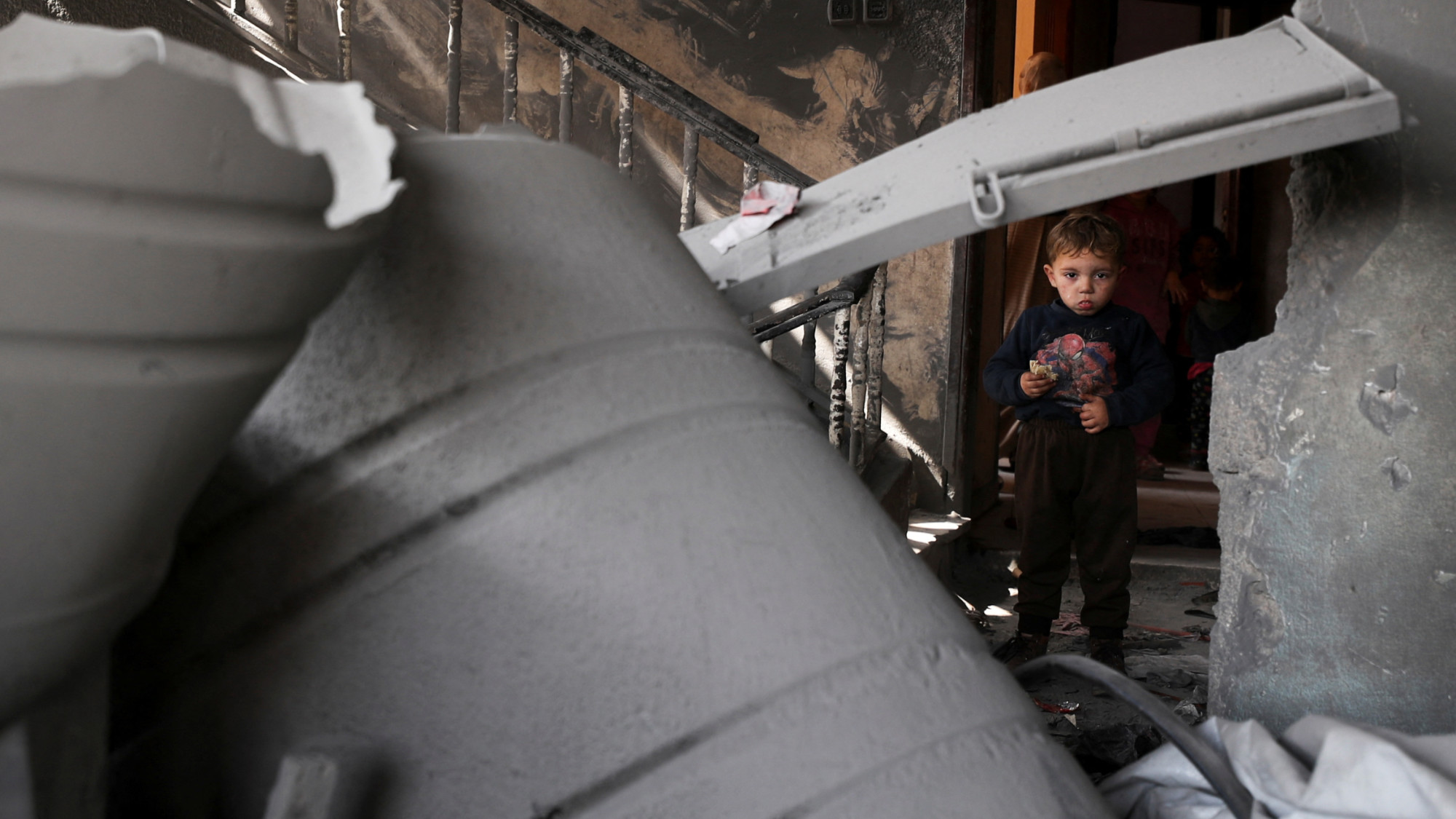 A Palestinian child stands at the site of an Israeli strike on a residential building in Jabalia in the northern Gaza Strip 18 March 2025 (Reuters/Mahmoud Issa)