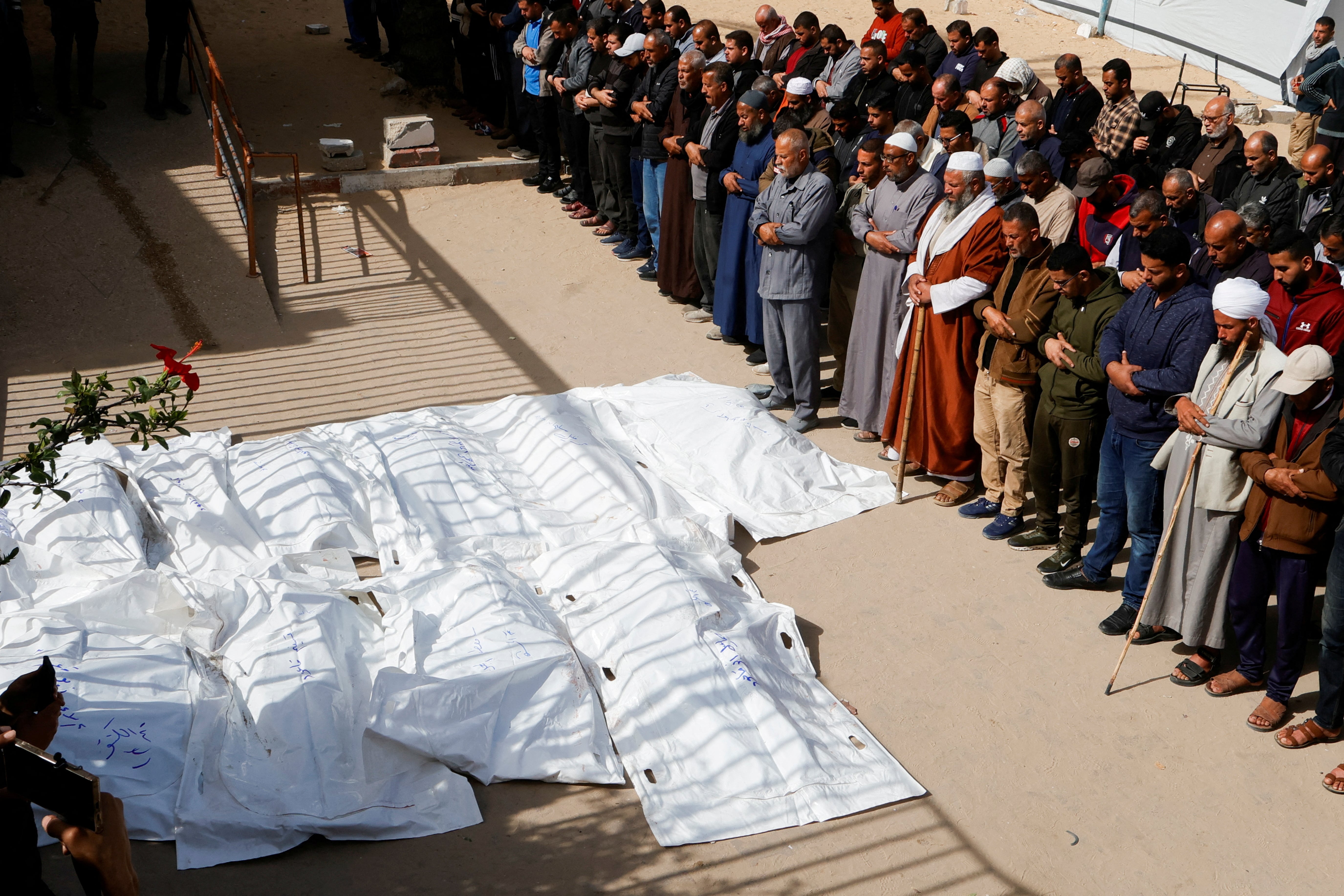 Mourners pray next to the bodies of Palestinians killed in Israeli strikes, at Nasser hospital, in Khan Younis, in the southern Gaza Strip, 2 April 2025. (REUTERS/Hatem Khaled)