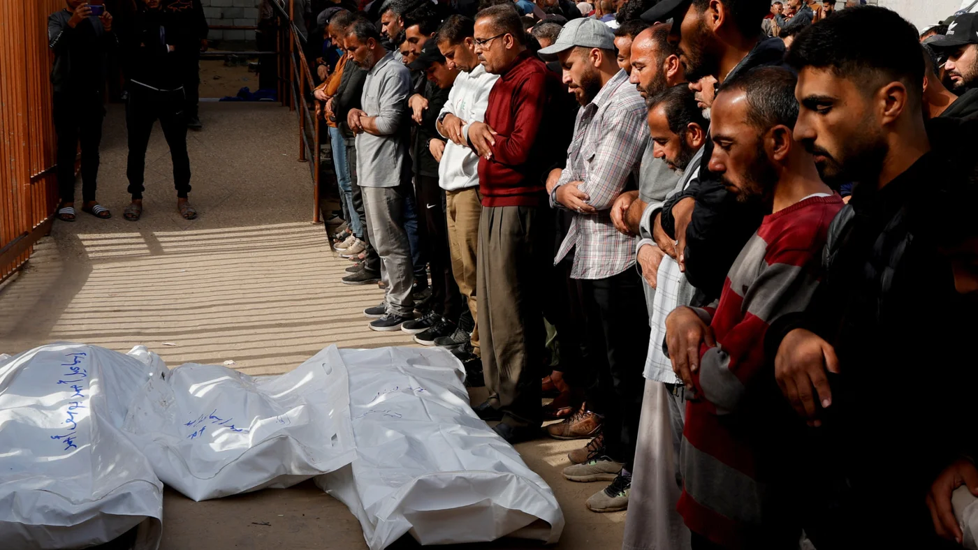 mourners pray next to bodies nasser hospital gaza
