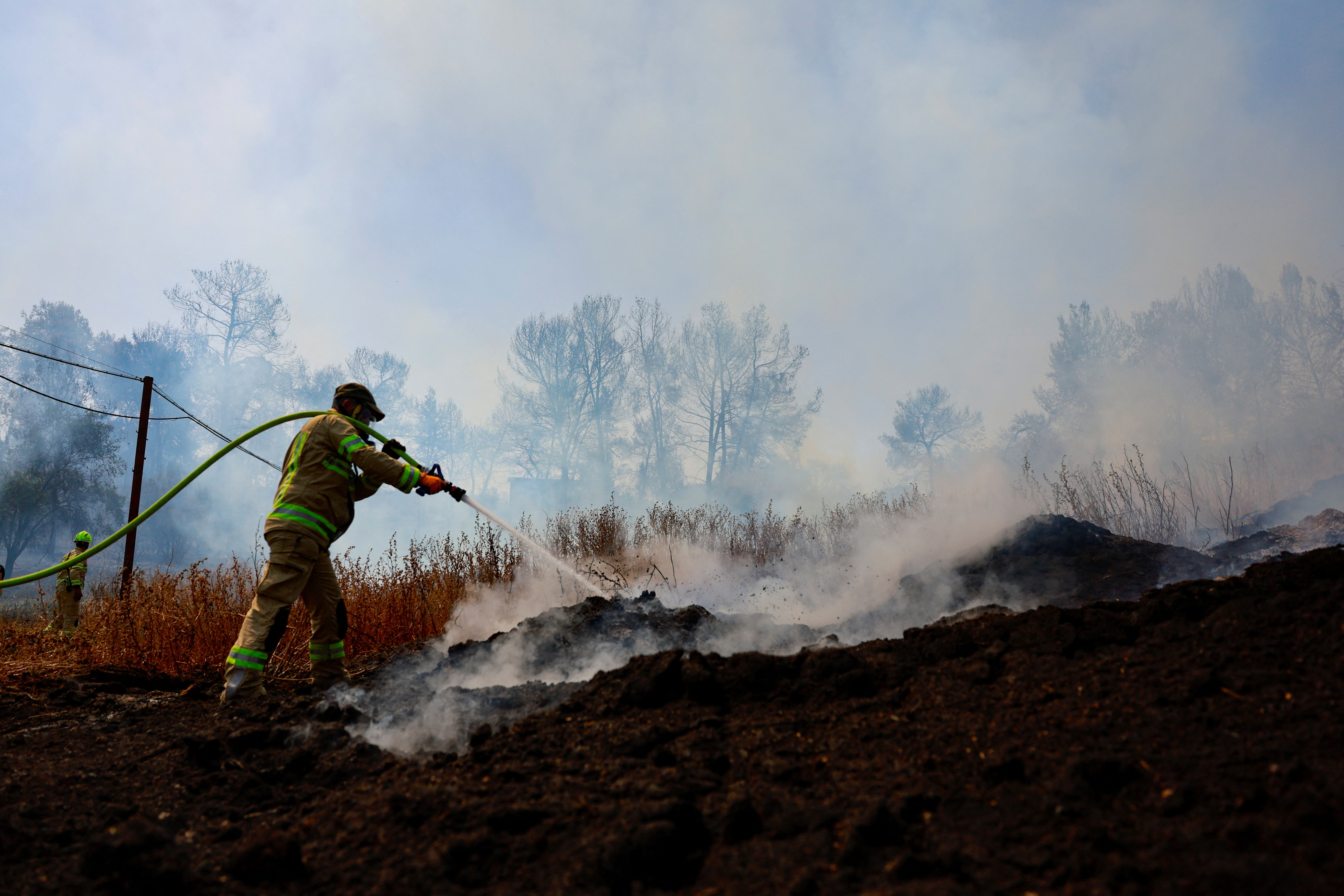A firefighter works near Latrun, a day after wildfires broke out due to extreme heat and winds, in central Israel, May 1, 2025. REUTERS/Ammar Awad
