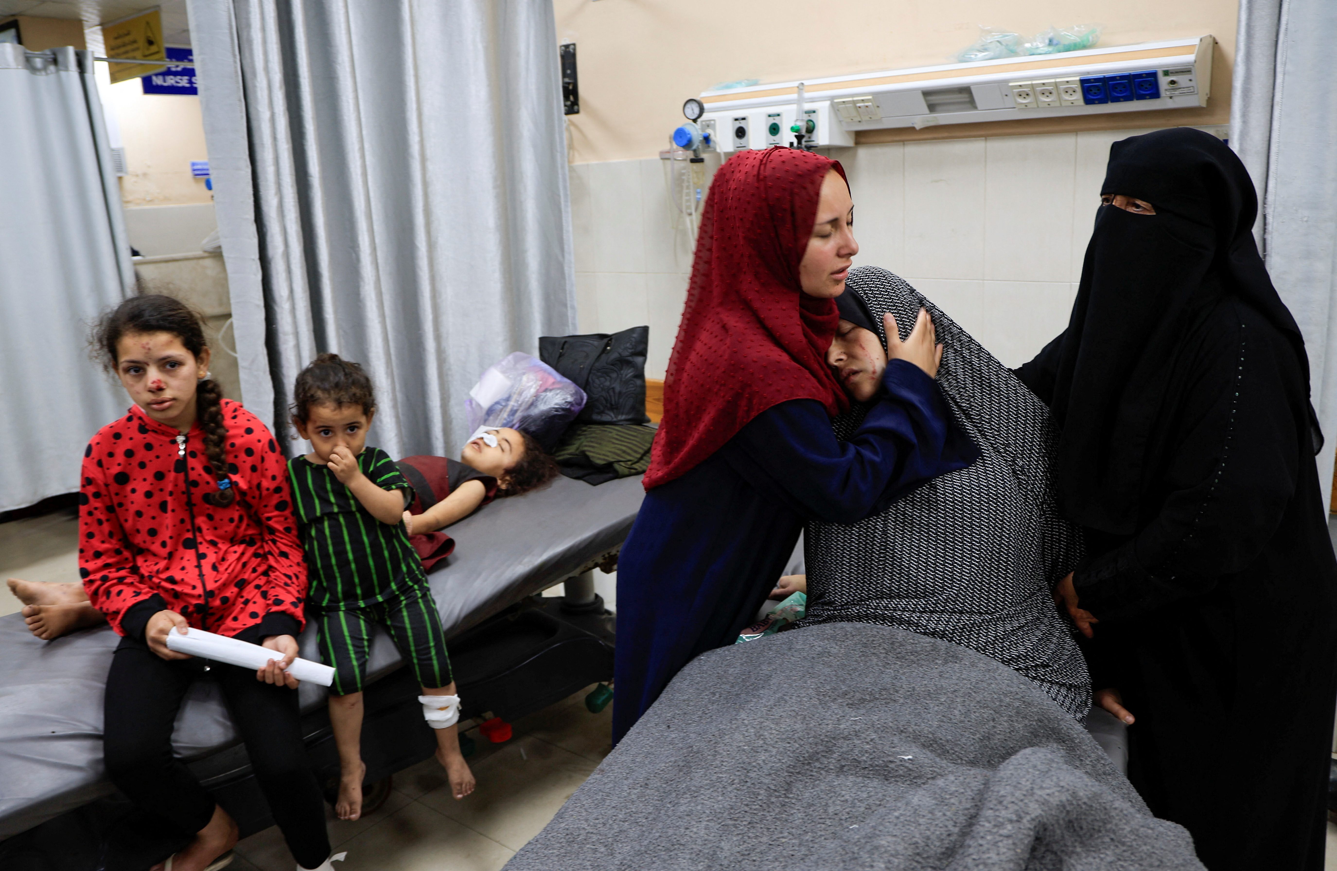 Injured Palestinian woman, Safa Al-Bayouk, weeps over her kids, Moath and Moataz, who were killed in Israeli strikes, as she lies on bed at Nasser hospital in Khan Younis, southern Gaza Strip, May 15, 2025.