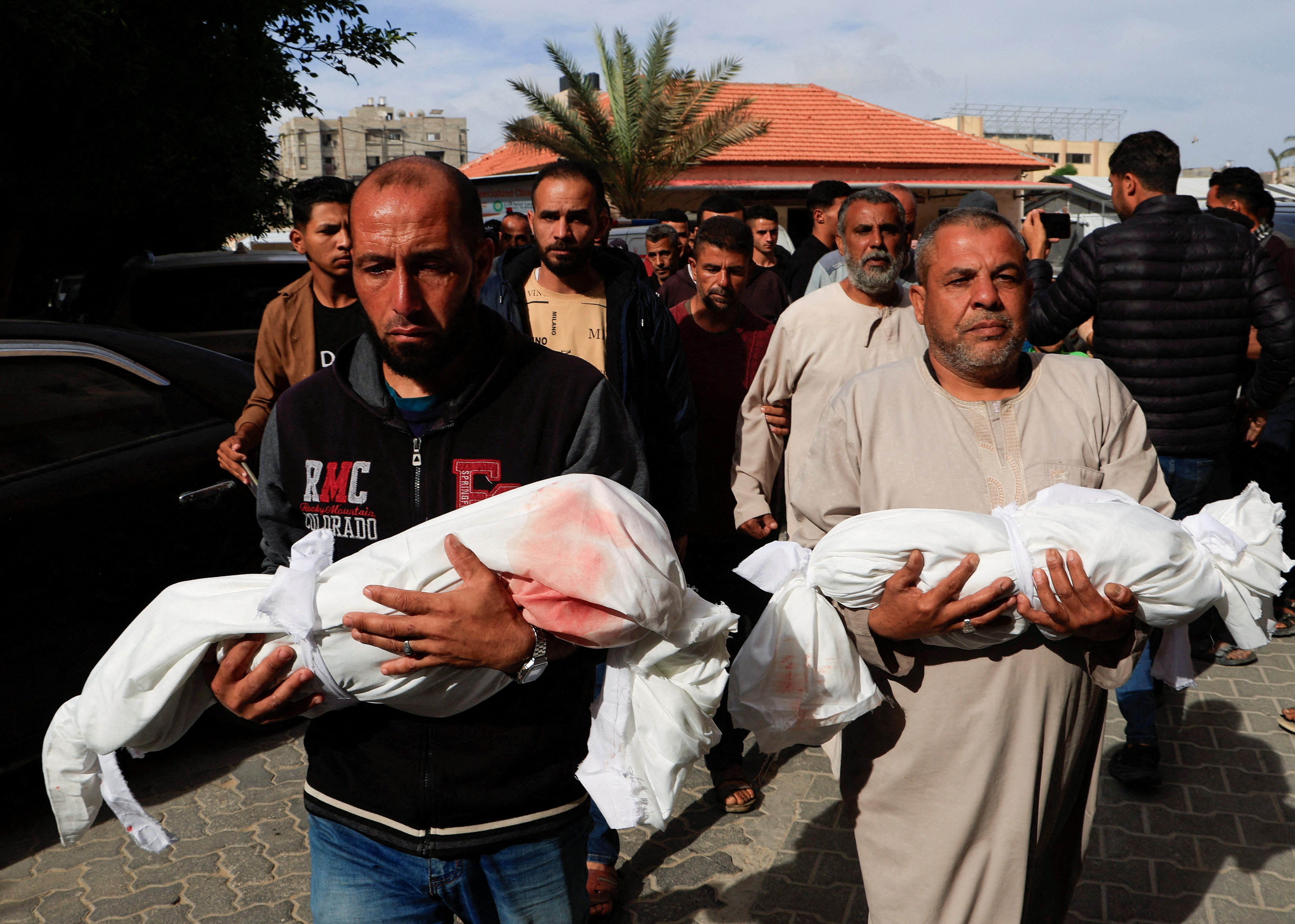 Palestinians carry the bodies of the two children, Moath and Moataz Al-Bayouk, who were killed in Israeli strikes, at Nasser hospital in Khan Younis, southern Gaza Strip, May 15, 2025. 