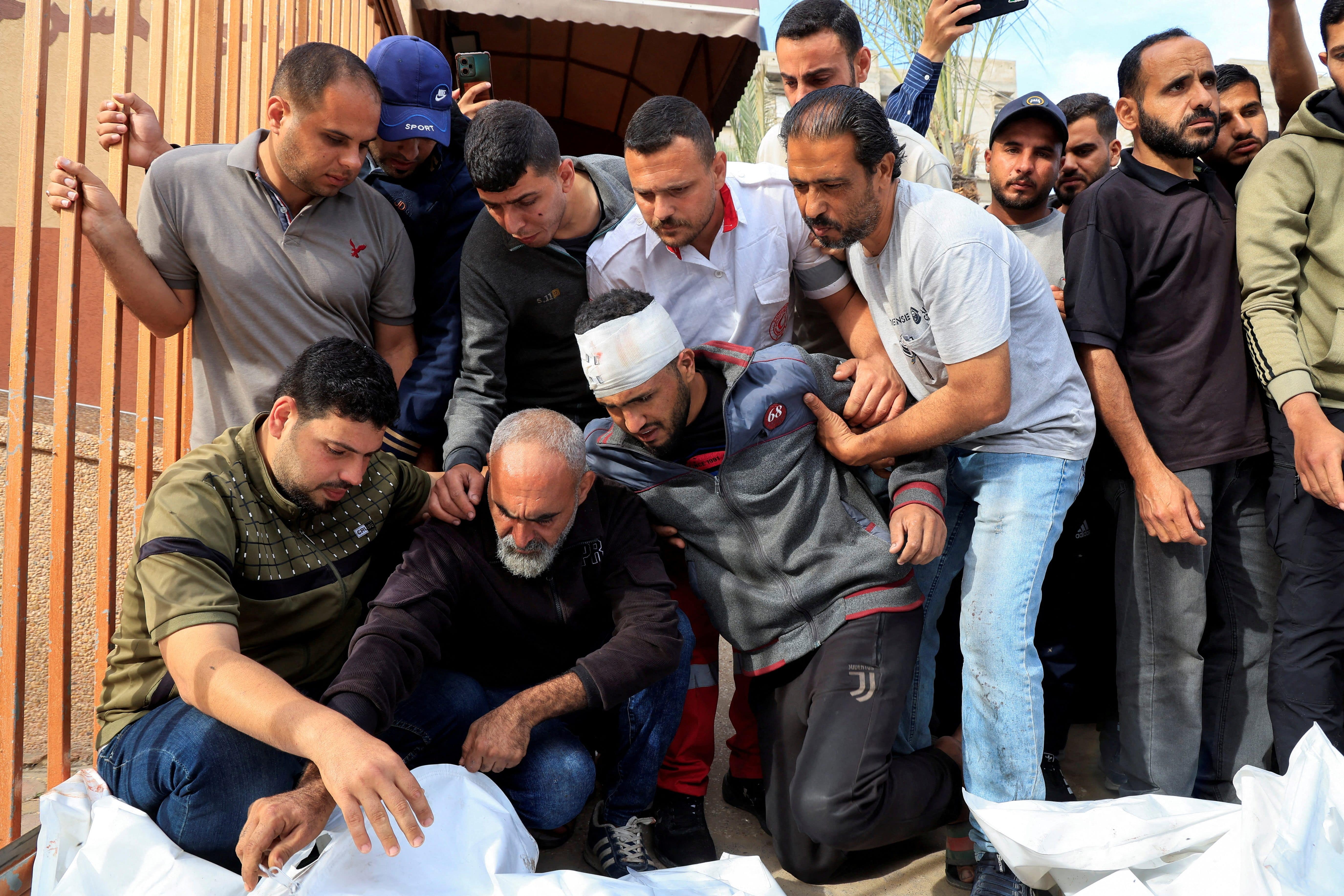 An injured Palestinian man bids farewell to his relatives killed in Israeli strikes, at Nasser hospital in Khan Younis, southern Gaza Strip, May 15, 2025. REUTERS/Hatem Khaled