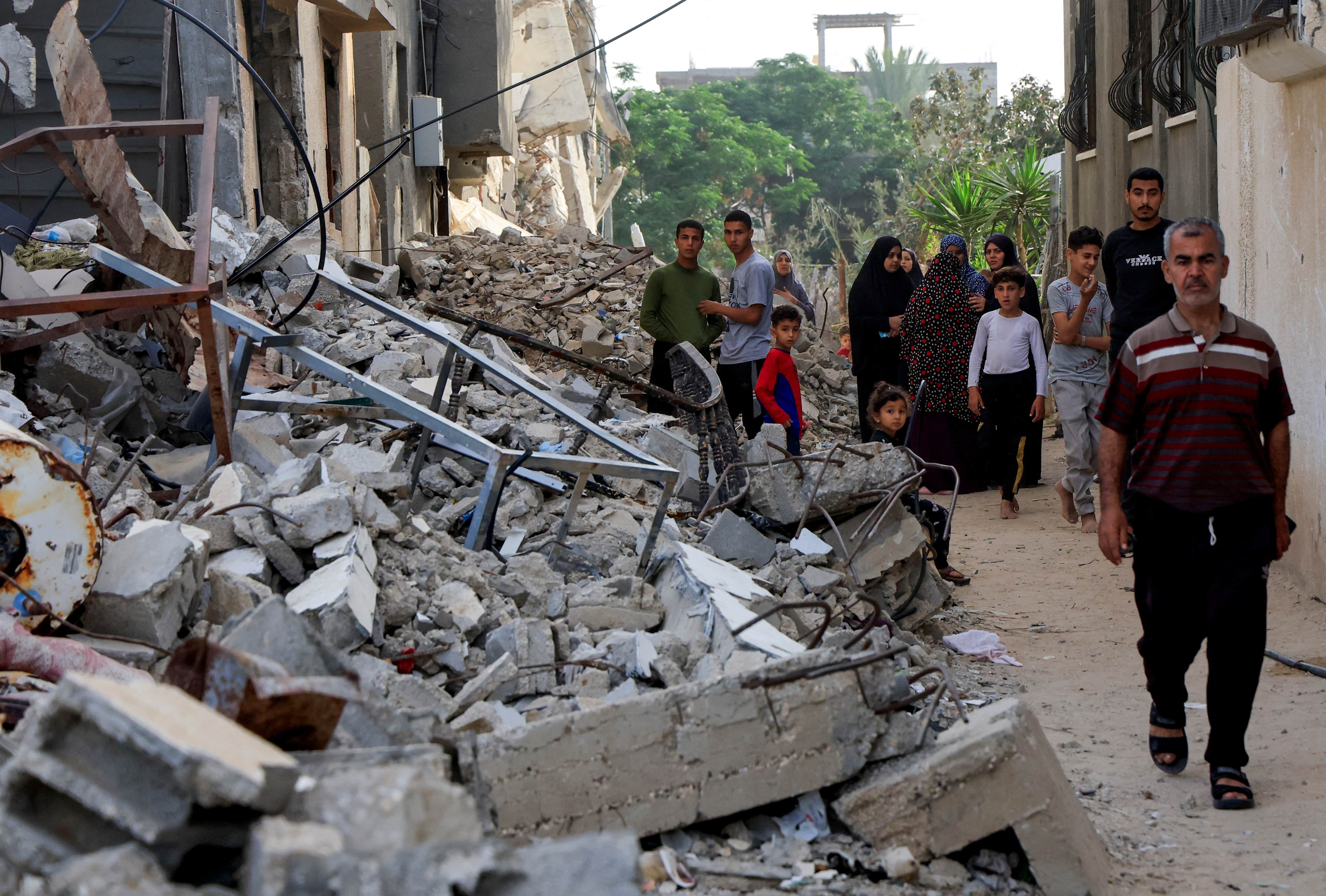Palestinians inspect the site of an Israeli strike, in Khan Younis, southern Gaza Strip, May 19, 2025. REUTERS