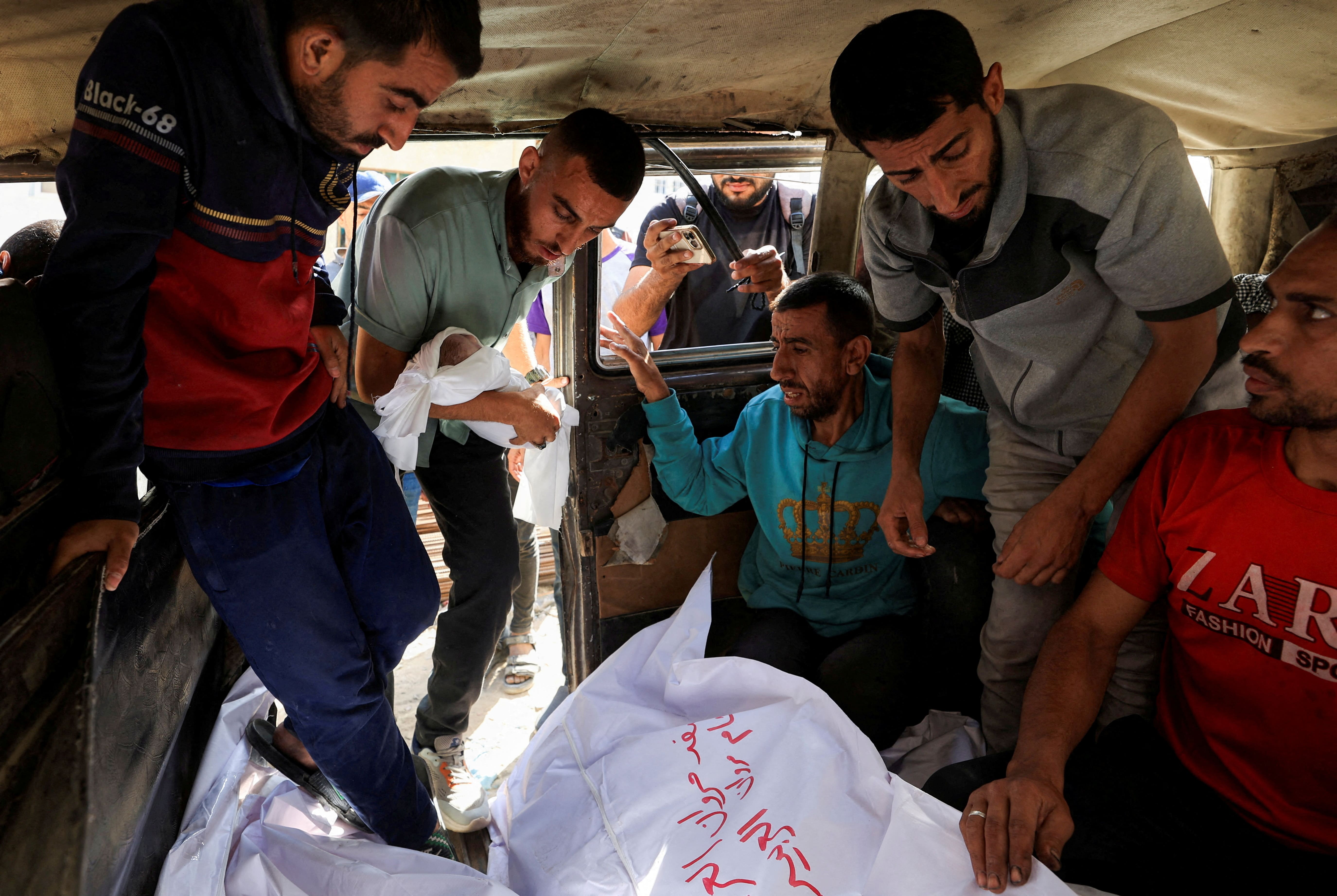 A Palestinian mourner carries the body of the stillborn baby of Palestinian woman Seham Al-Arabeed, who was killed in an a Israeli strike, according to medics, in Gaza City, May 28, 2025.