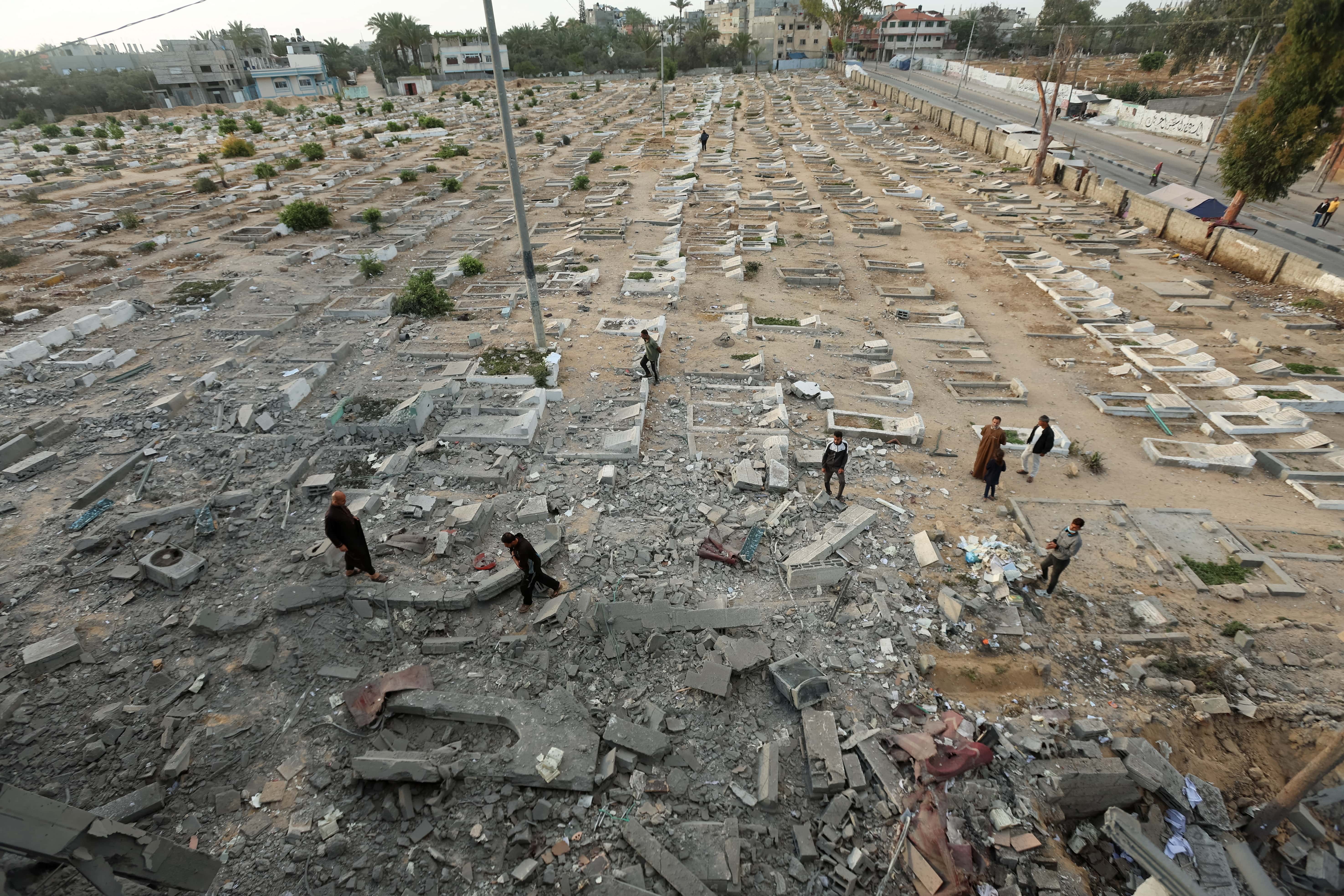 Palestinians inspect a cemetery damaged in Israeli shelling, in Deir Al-Balah, in the central Gaza Strip, June 2, 2025. REUTERS/Ramadan Abed