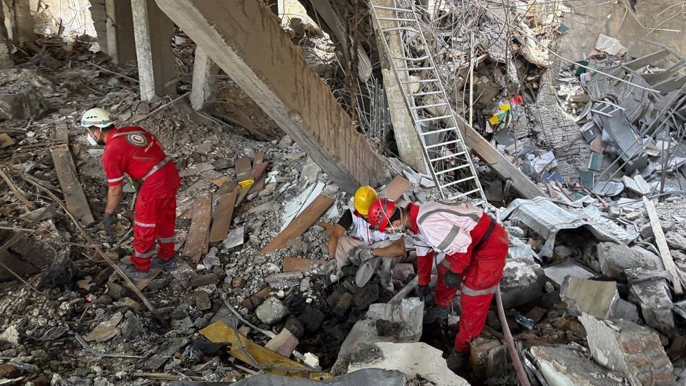 Iranian rescue workers search through rubble after an Israeli air strike on Tehran, 27 June 2025 (ZUMA/Reuters)