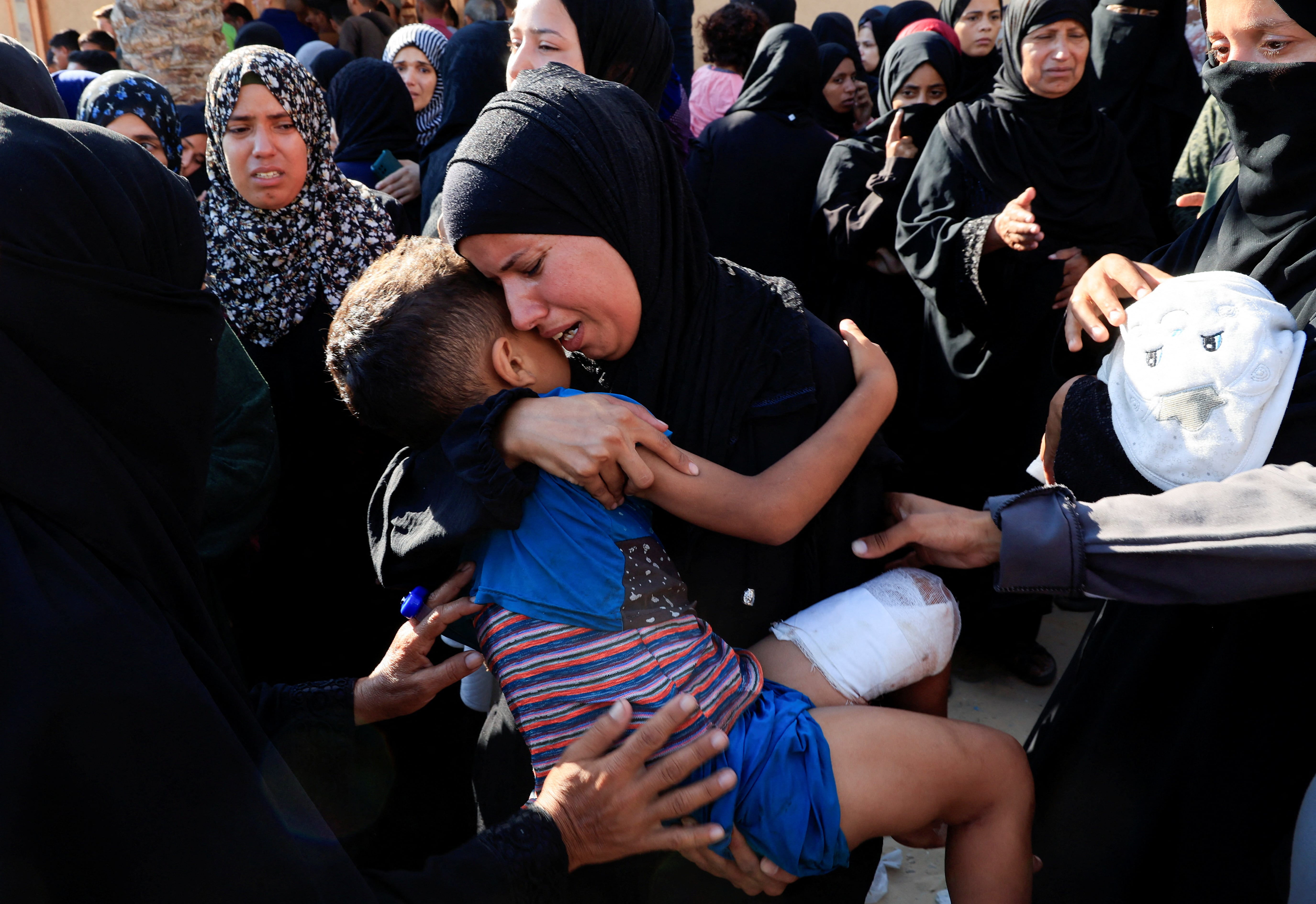 A mourner reacts holding a child during the funeral of Palestinians, who, according to Gaza's health ministry, were killed in an overnight Israeli strike on a tent, at Nasser Hospital in Khan Younis, southern Gaza Strip, July 3, 2025. REUTERS/Hatem Khaled TPX IMAGES OF THE DAY