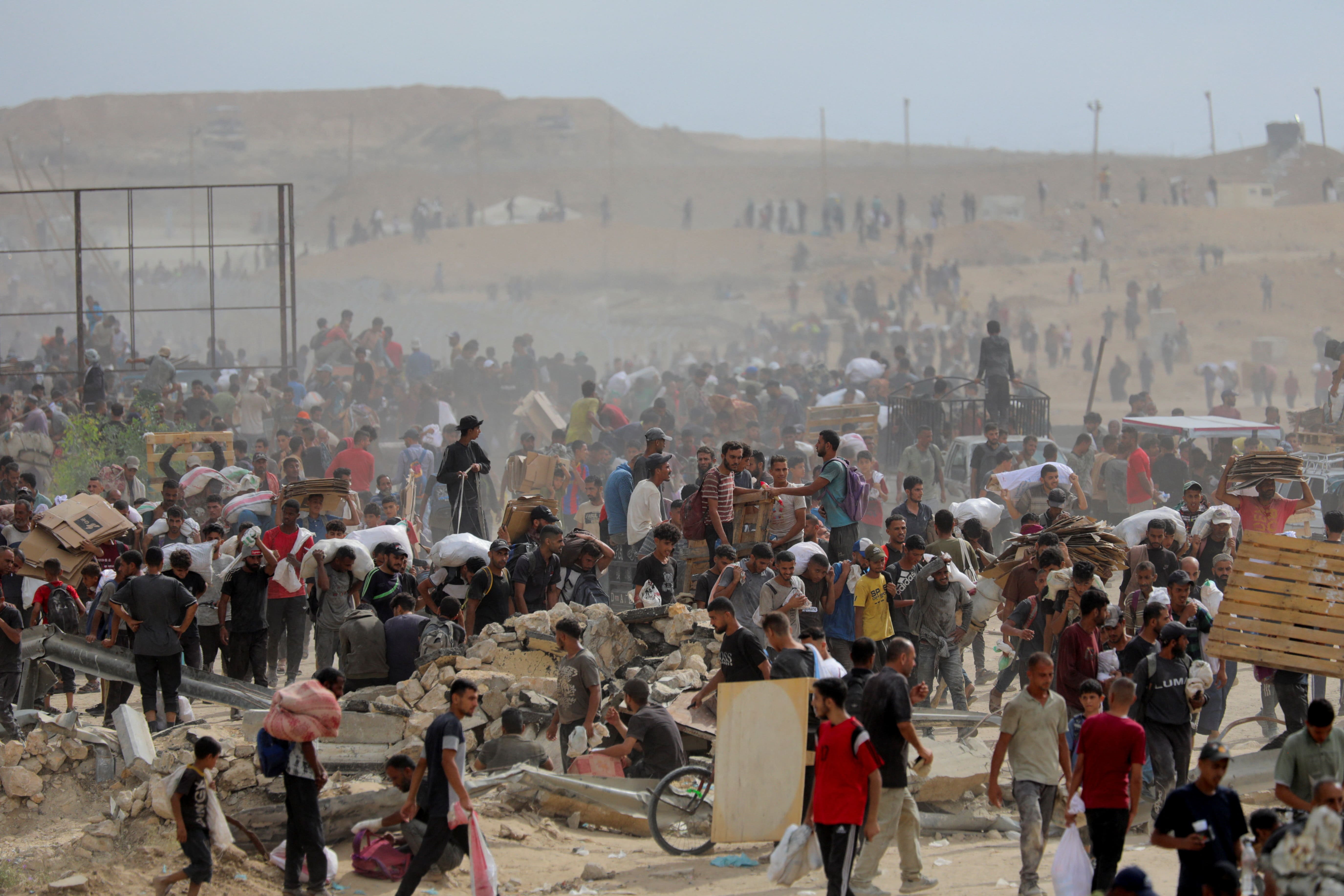 Palestinians carry aid supplies which they received from the U.S.-backed Gaza Humanitarian Foundation (GHF), in the central Gaza Strip, August 1, 2025. REUTERS