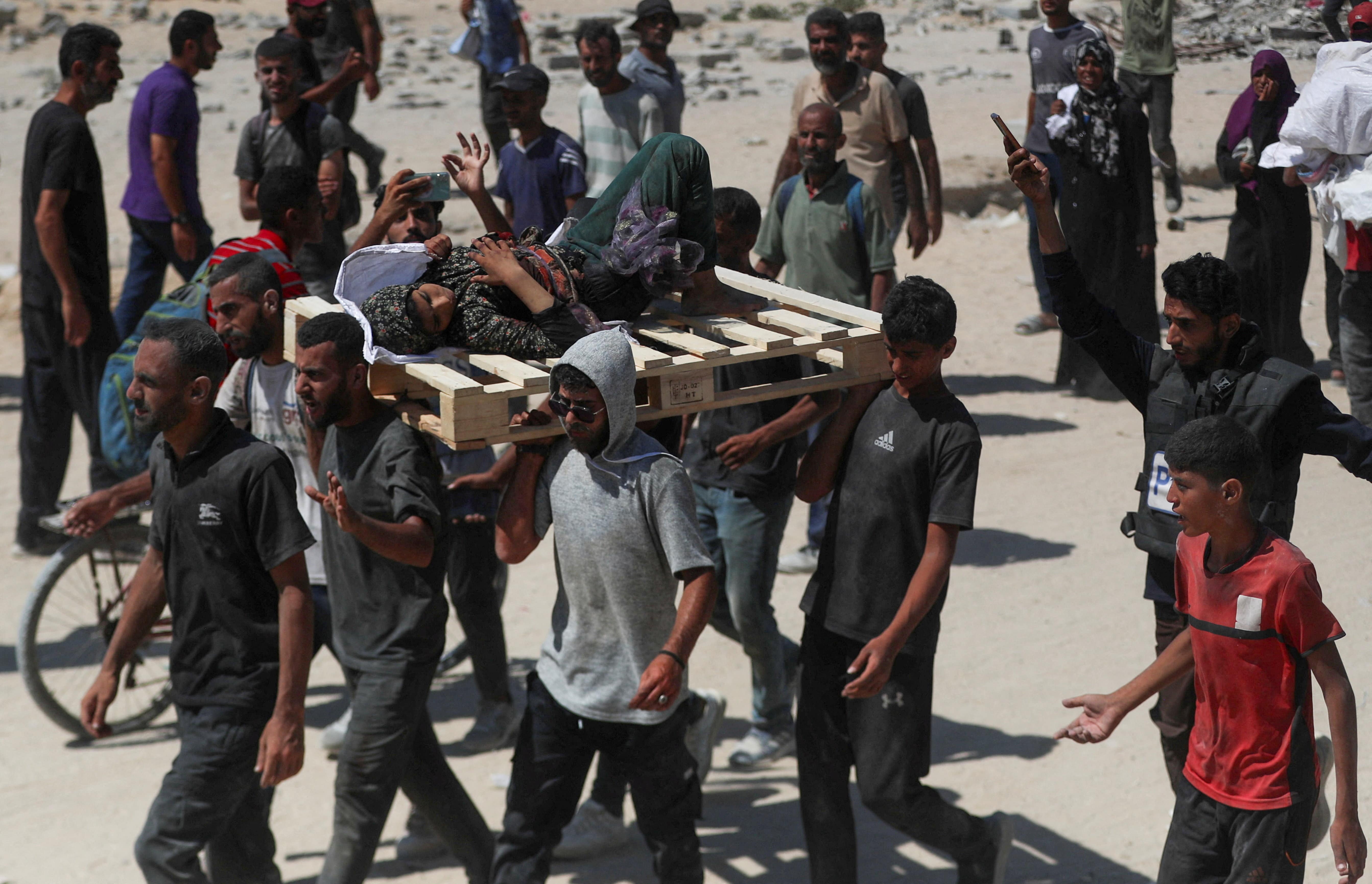 Palestinians carry a woman that was wounded by Israeli fire, as others seek for aid supplies that entered Gaza through Israel, in Beit Lahia, northern Gaza Strip, August 1, 2025. REUTERS