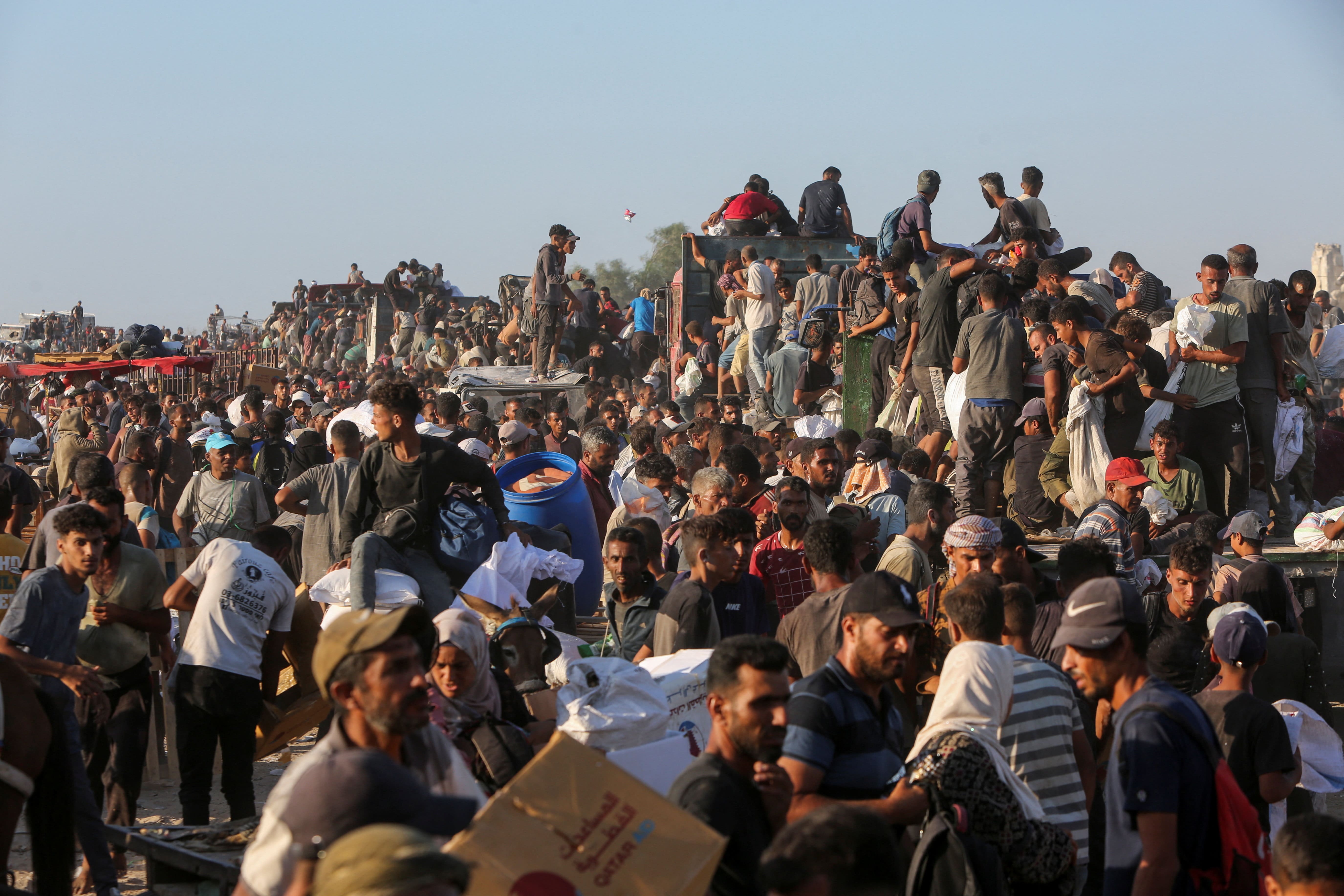 Palestinians carry aid supplies in Khan Younis, southern Gaza Strip, 4 August, 2025. (Reuters)