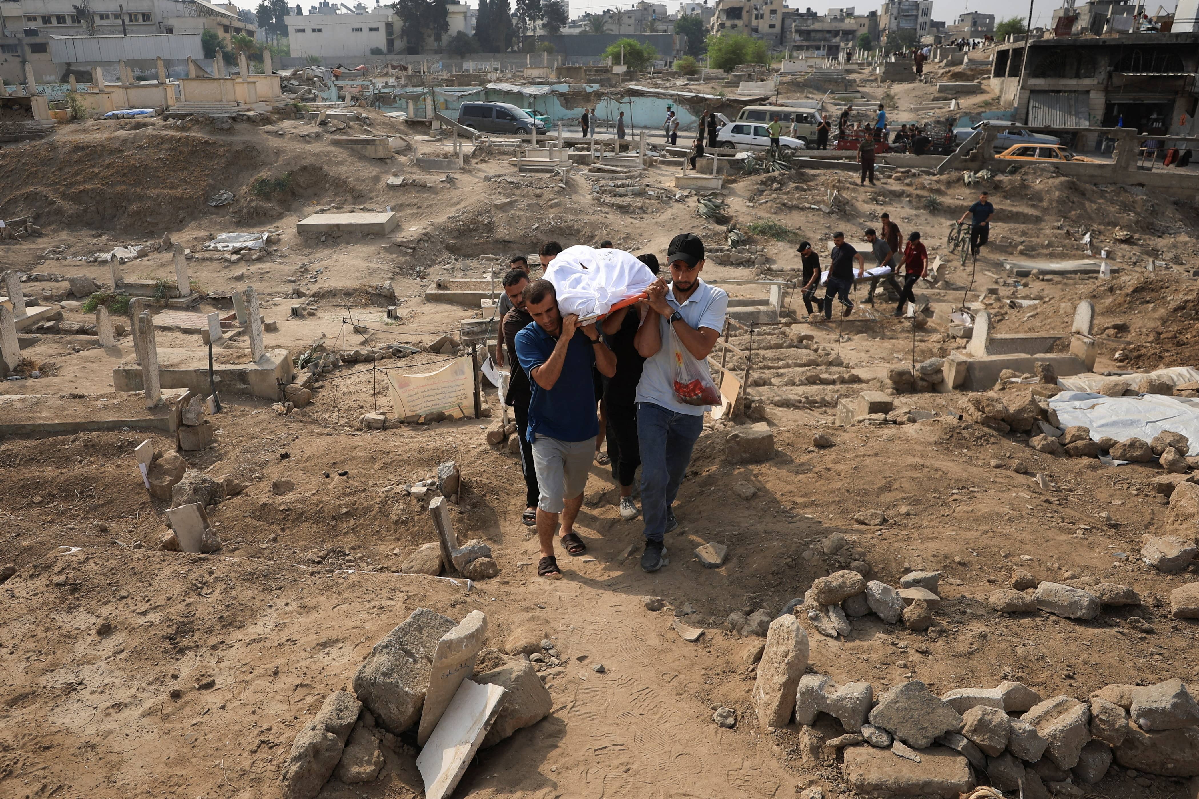 Mourners carry the bodies of Palestinians killed in an early morning Israeli strike on a house, according to medics, in Gaza City, 13 August 2025. (Reuters)