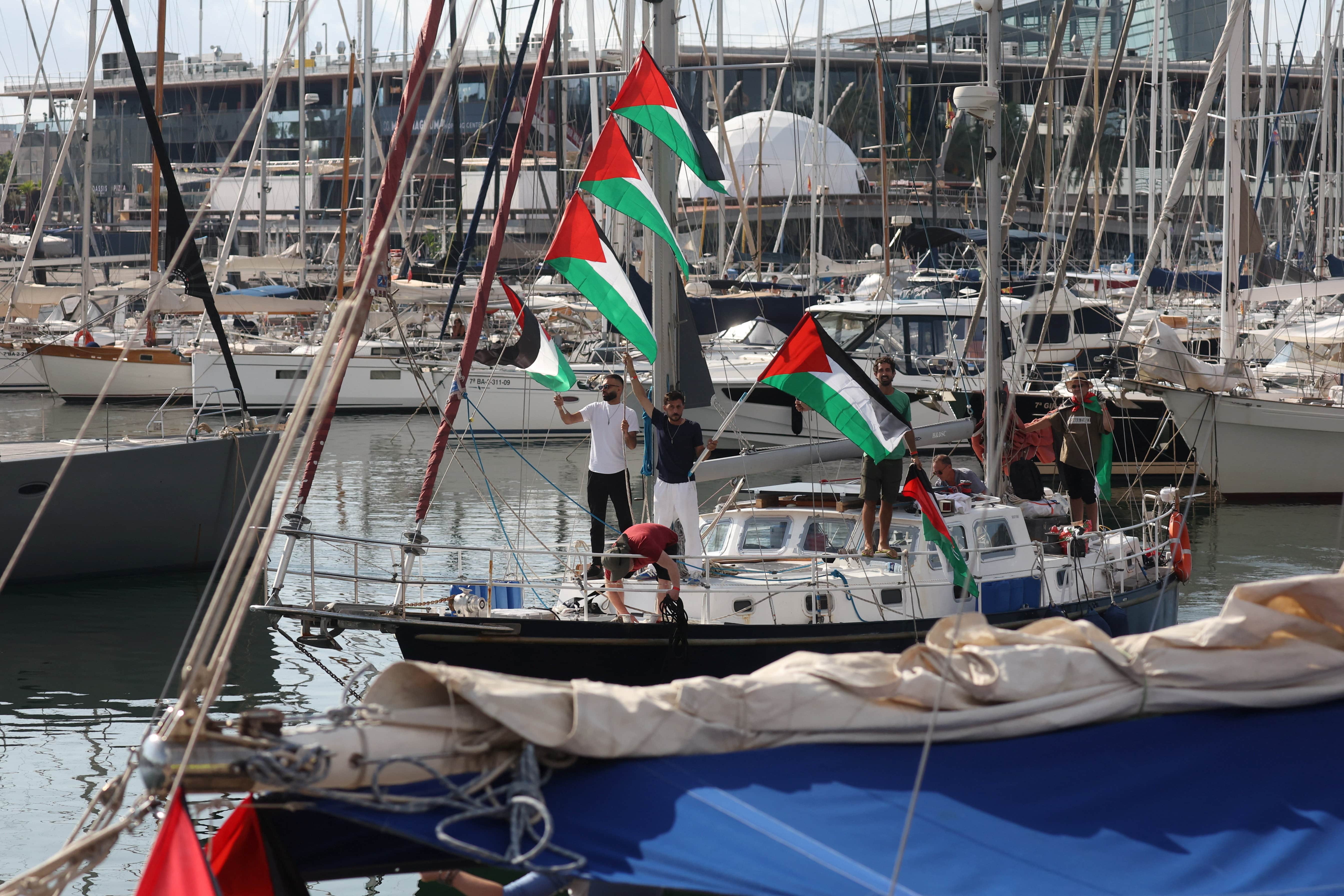 Activists display Palestinian flags on a boat, before the Global Sumud Flotilla is set to sail from Barcelona, Spain, to Gaza (Reuters/Bruna Casas)