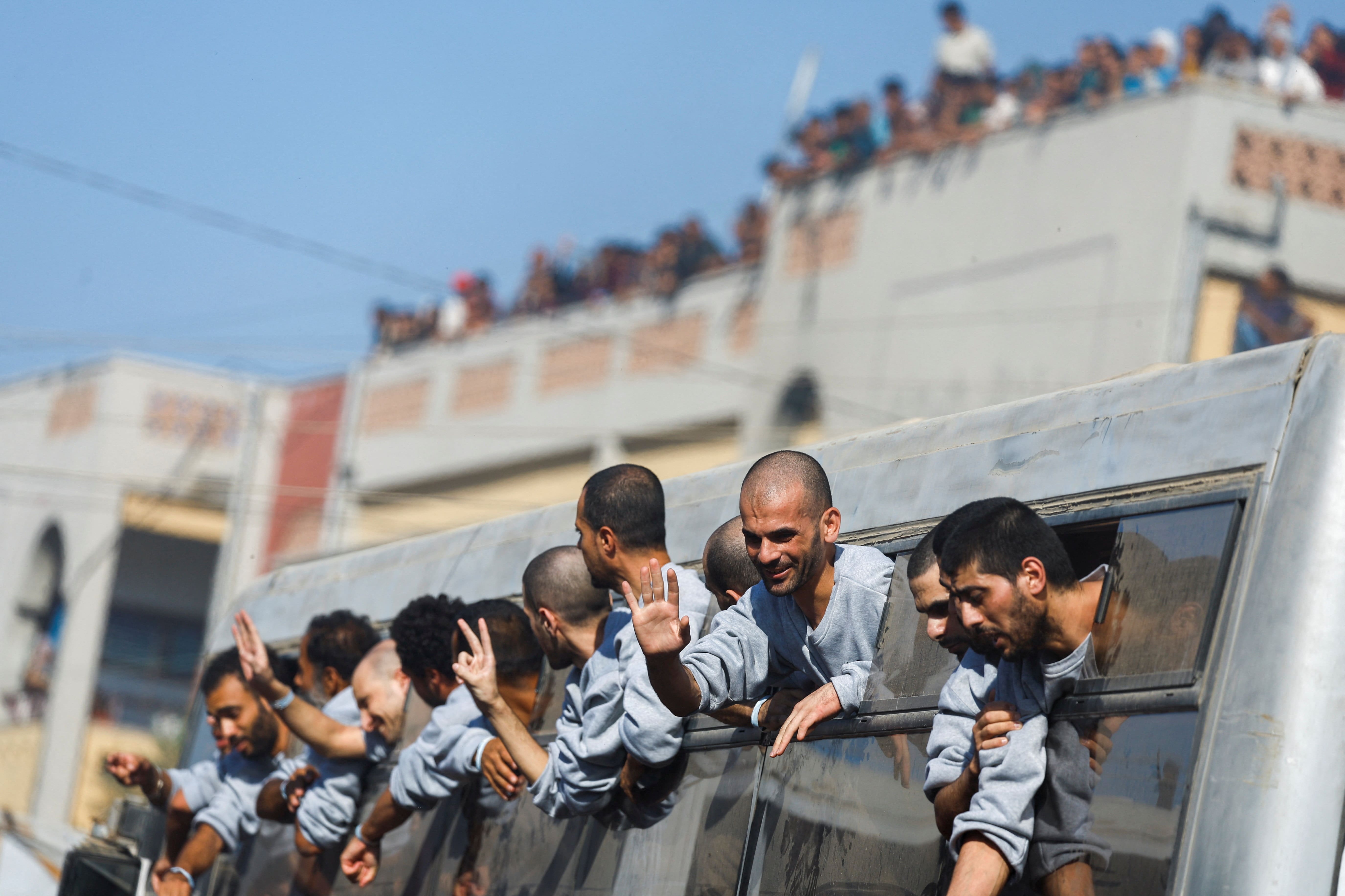 Freed Palestinian prisoners gesture from a bus after they were released by Israel as part of a captive-prisoner swap and a ceasefire deal between Hamas and Israel, in Khan Younis in the southern Gaz