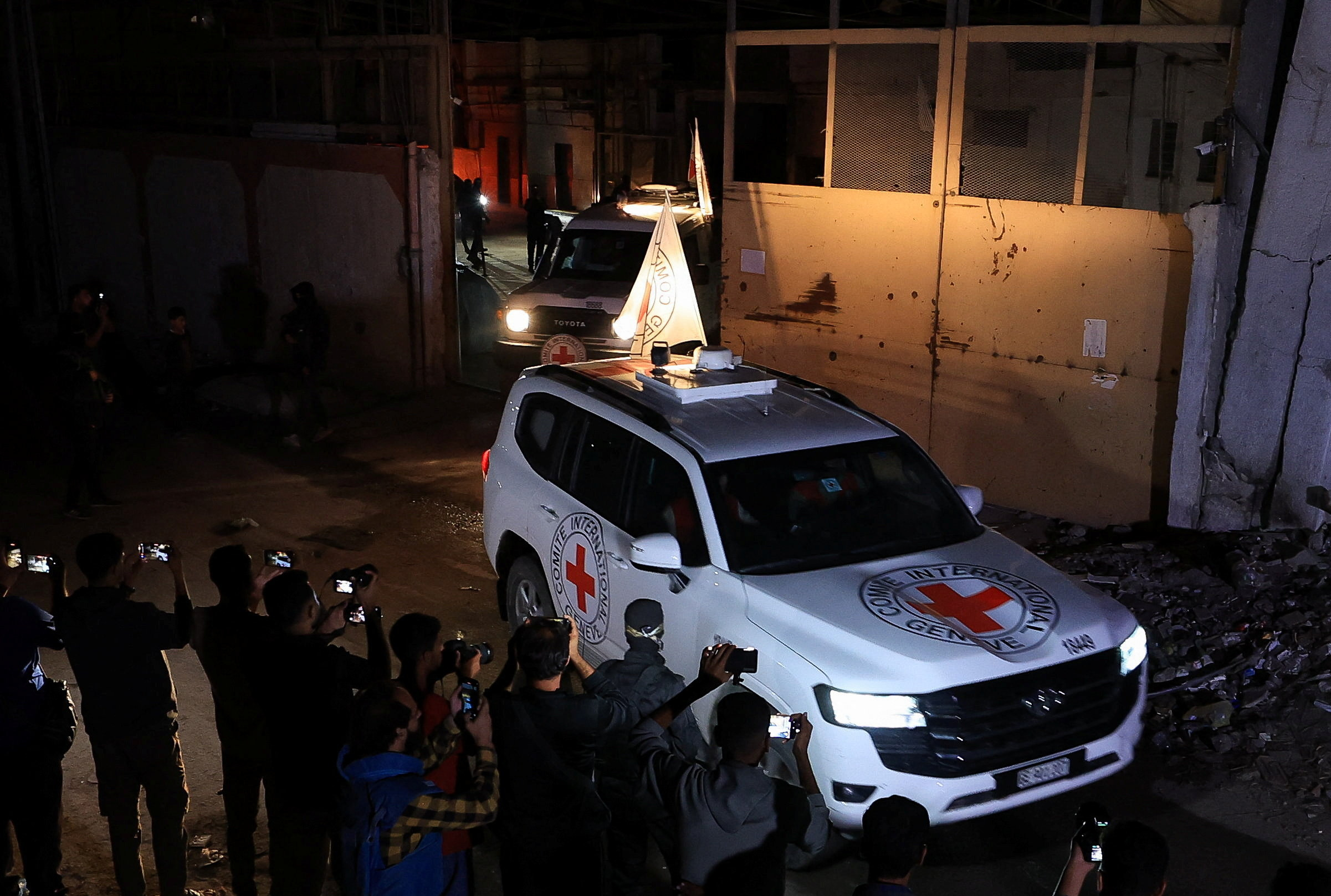 Red Cross vehicles transport the bodies of deceased captives after they were handed over by Hamas militants as part of a ceasefire and a hostages-prisoners swap deal between Hamas and Israel, in Gaza