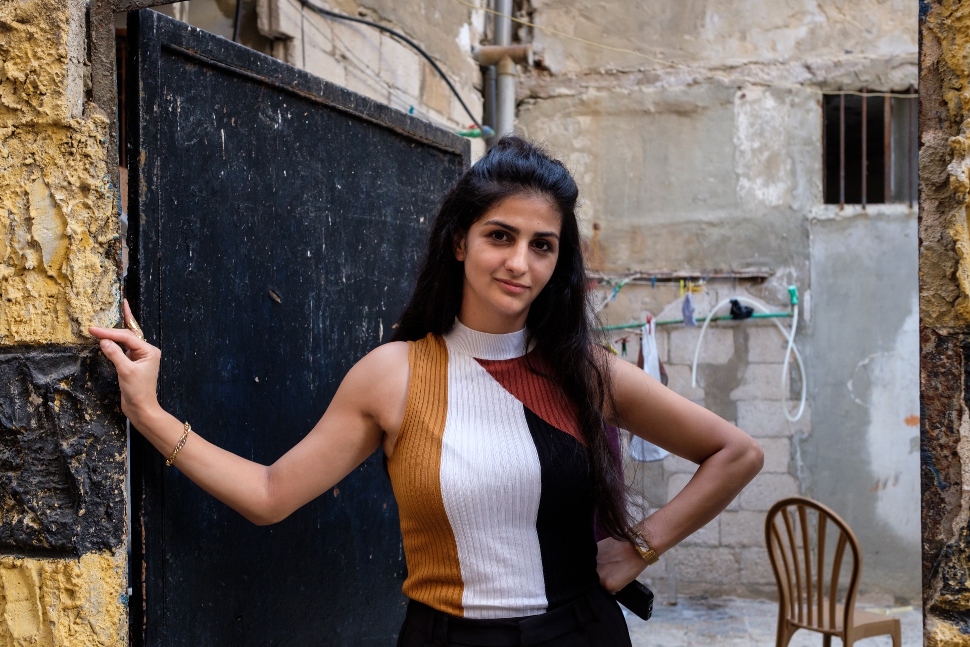Yasmine Ahmad Hazineh in front of her family’s home in Shatila. Yasmine wants to pass the stories of the massacres down to her children (MEE/Rita Kabalan)
