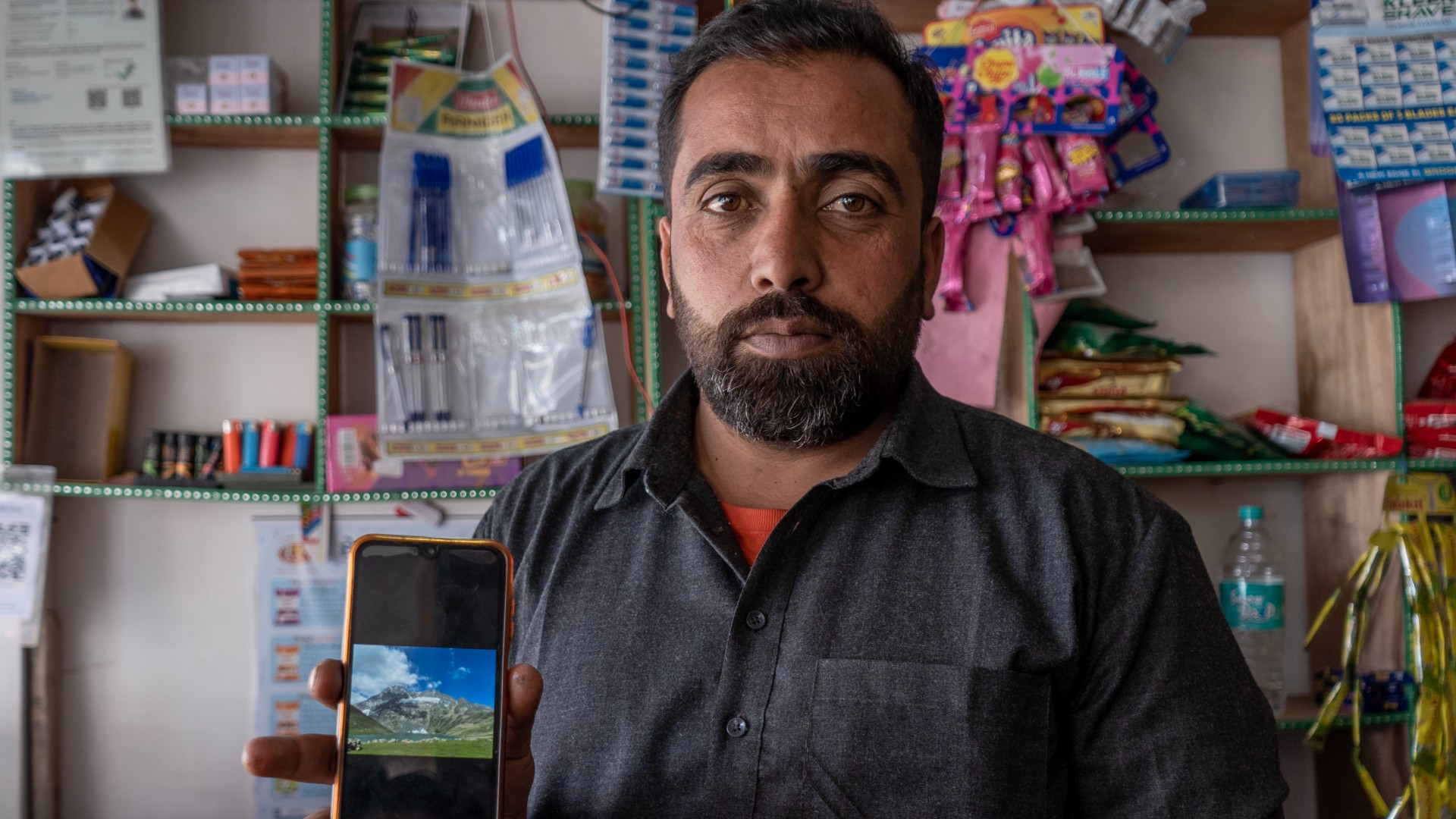 Ghulam Qadir Jagil, a trekking guide, shows a view of Gangbal Lake on his phone. He used to take dozens of groups of trekkers to Kashmir’s seven great alpine lakes 