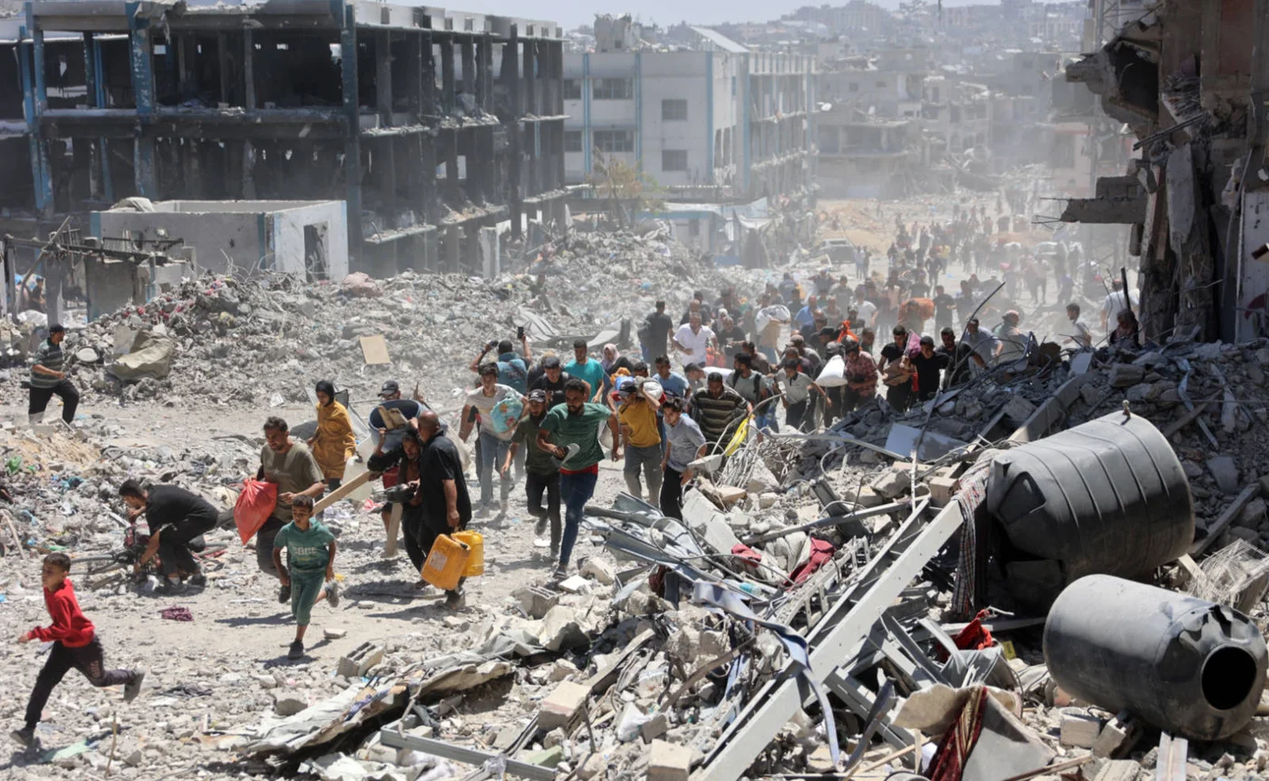 Palestinians flee Israeli tanks in Khan Younis, southern Gaza, 26 January 2024 (AFP)