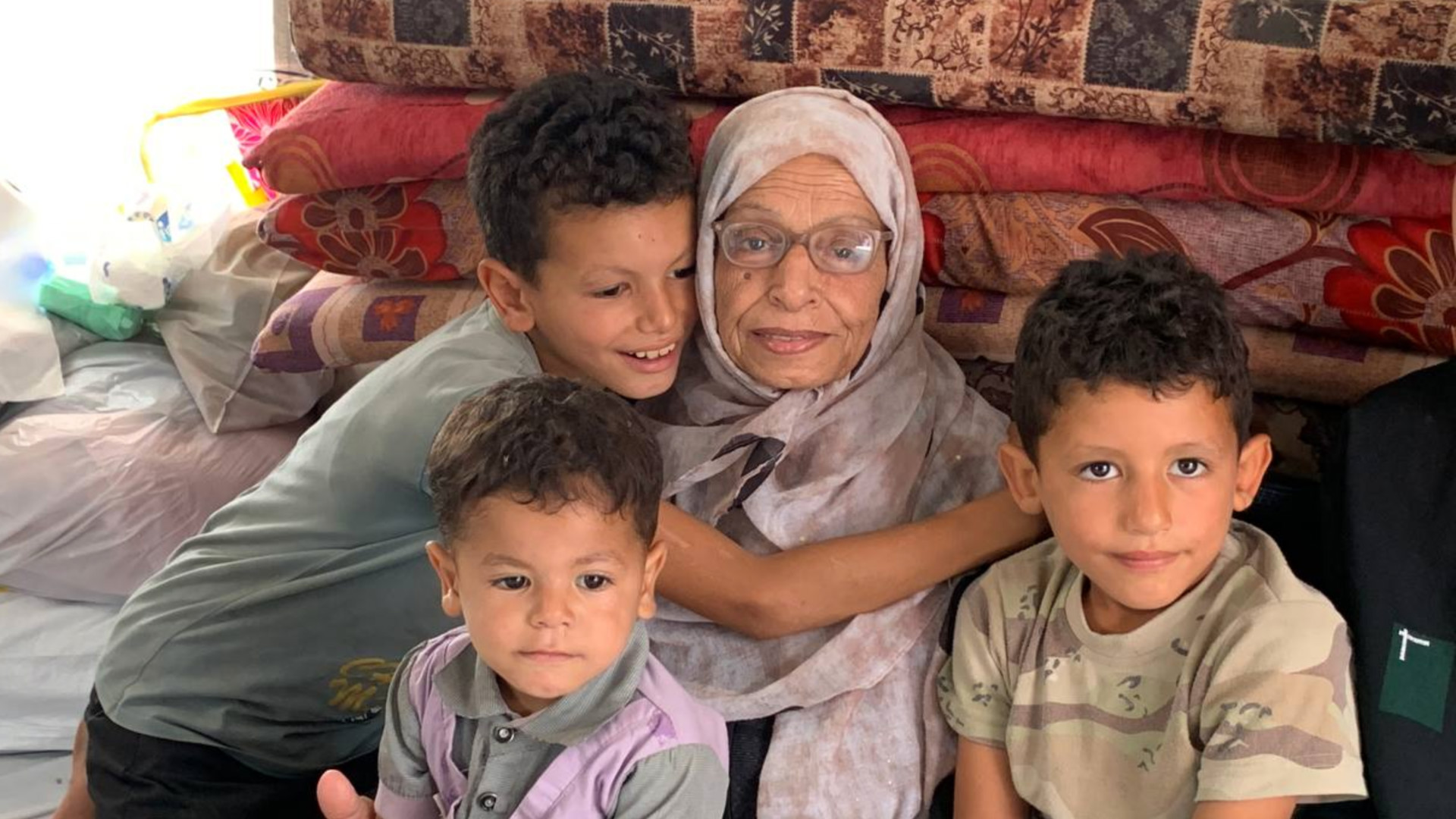 Aziza Qishta surrounded by her grandchildren (MEE/Ahmad Aziz)