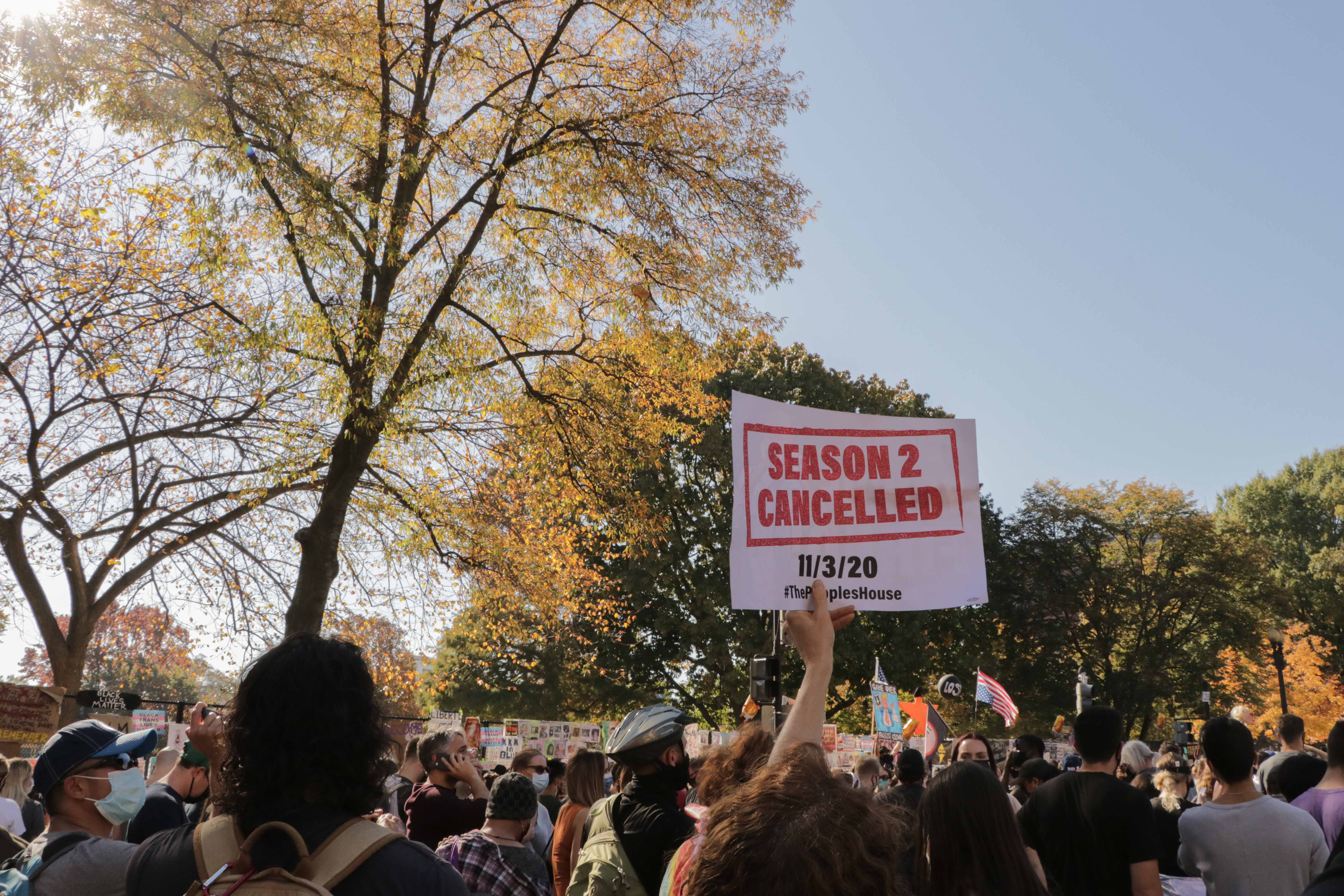 A Biden supporter holds a sign reading 'Season 2 cancelled' near the White House (MEE/Umar Farooq)