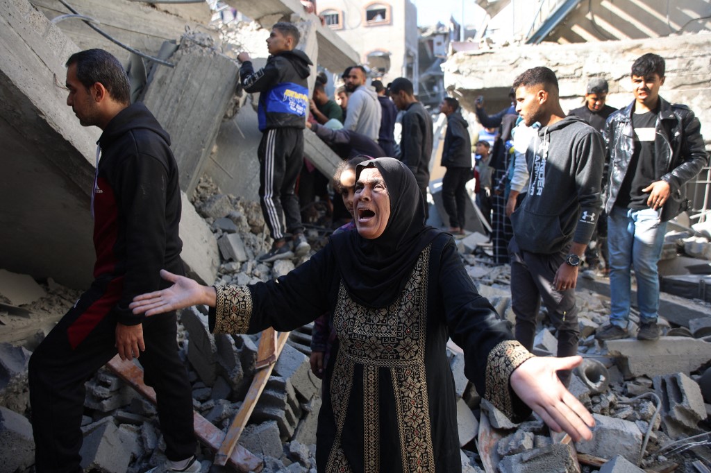 A Palestinian woman stands amid the rubble of a building destroyed in an Israeli strike on the Shujaiyah neighbourhood in Gaza City on 30 November 2024 (Omar al-Qattaa/AFP)
