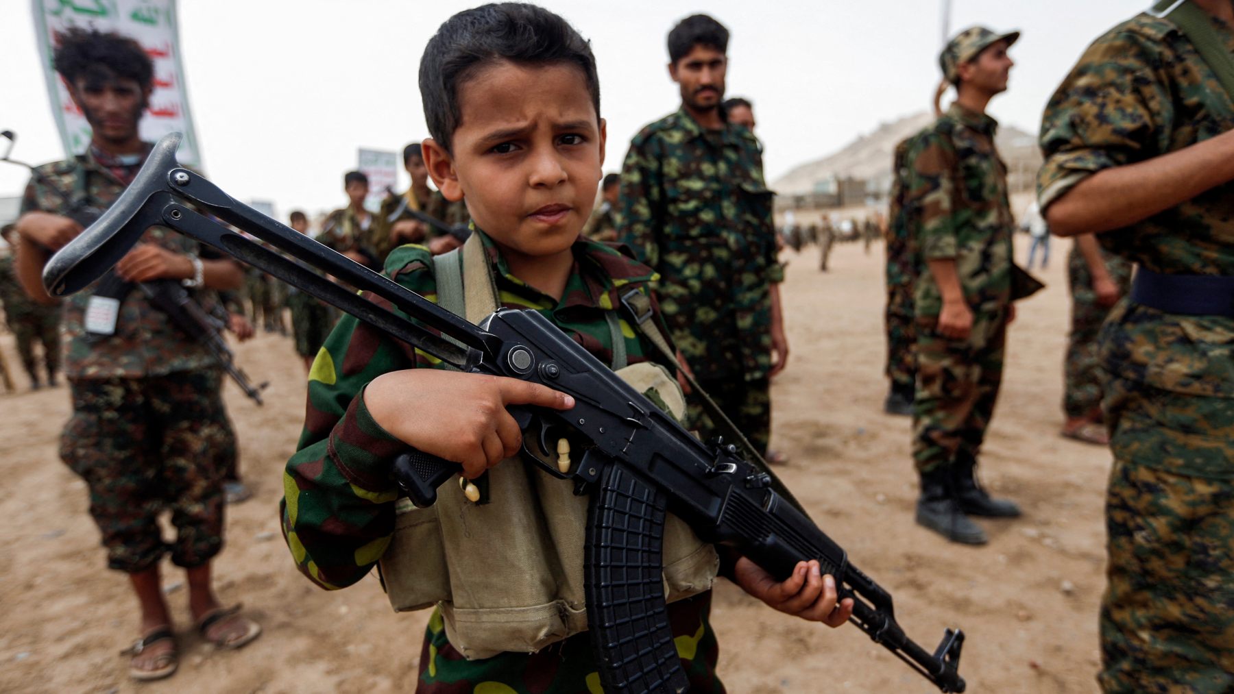 A Yemeni boy poses with a Kalashnikov during a gathering of newly recruited Huthi fighters in Sanaa, 16 July 2017 (Mohammed Huwais/AFP)