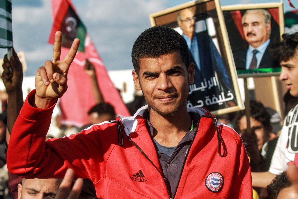 A supporter gestures during a speech by Libya's eastern military chief Khalifa Haftar (unseen) at a rally marking the 71st anniversary of the country's independence, Benghazi, 24 December 2022 (AFP)