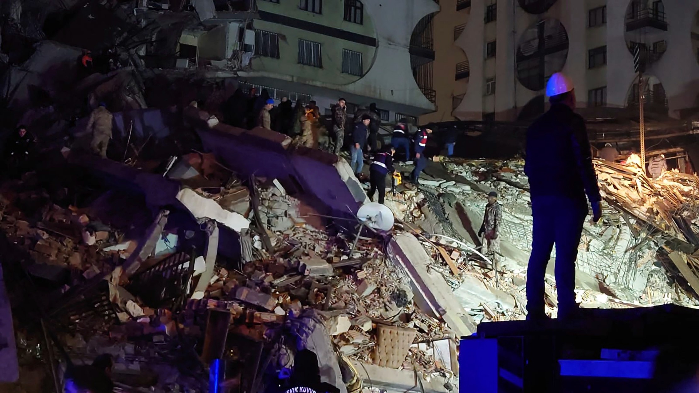 People try to reach trapped residents in a collapsed building in Diyarbakir, southeastern Turkey (AP)