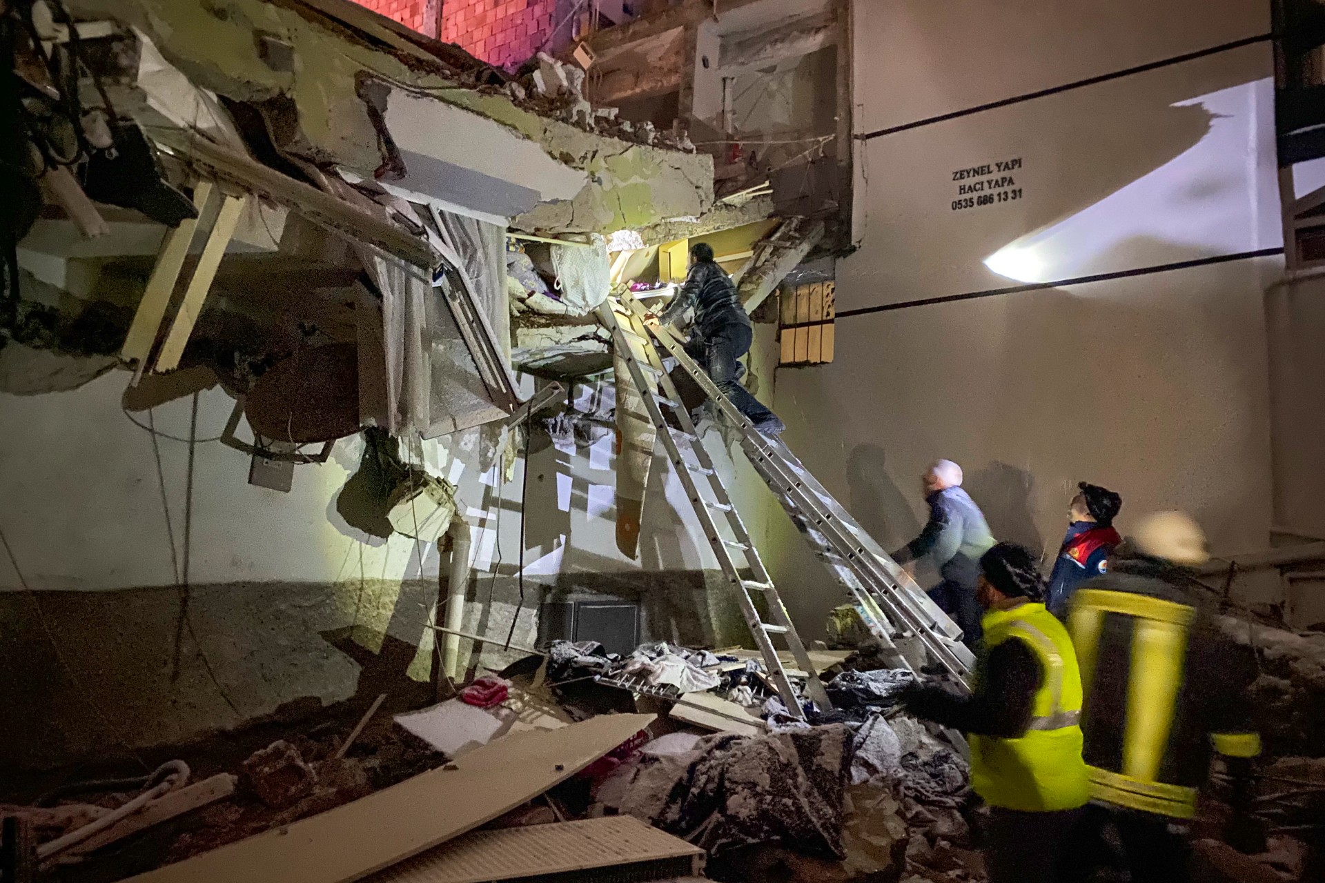 Rescue teams try to reach trapped residents inside collapsed buildings in Adana, Turkey (AP)
