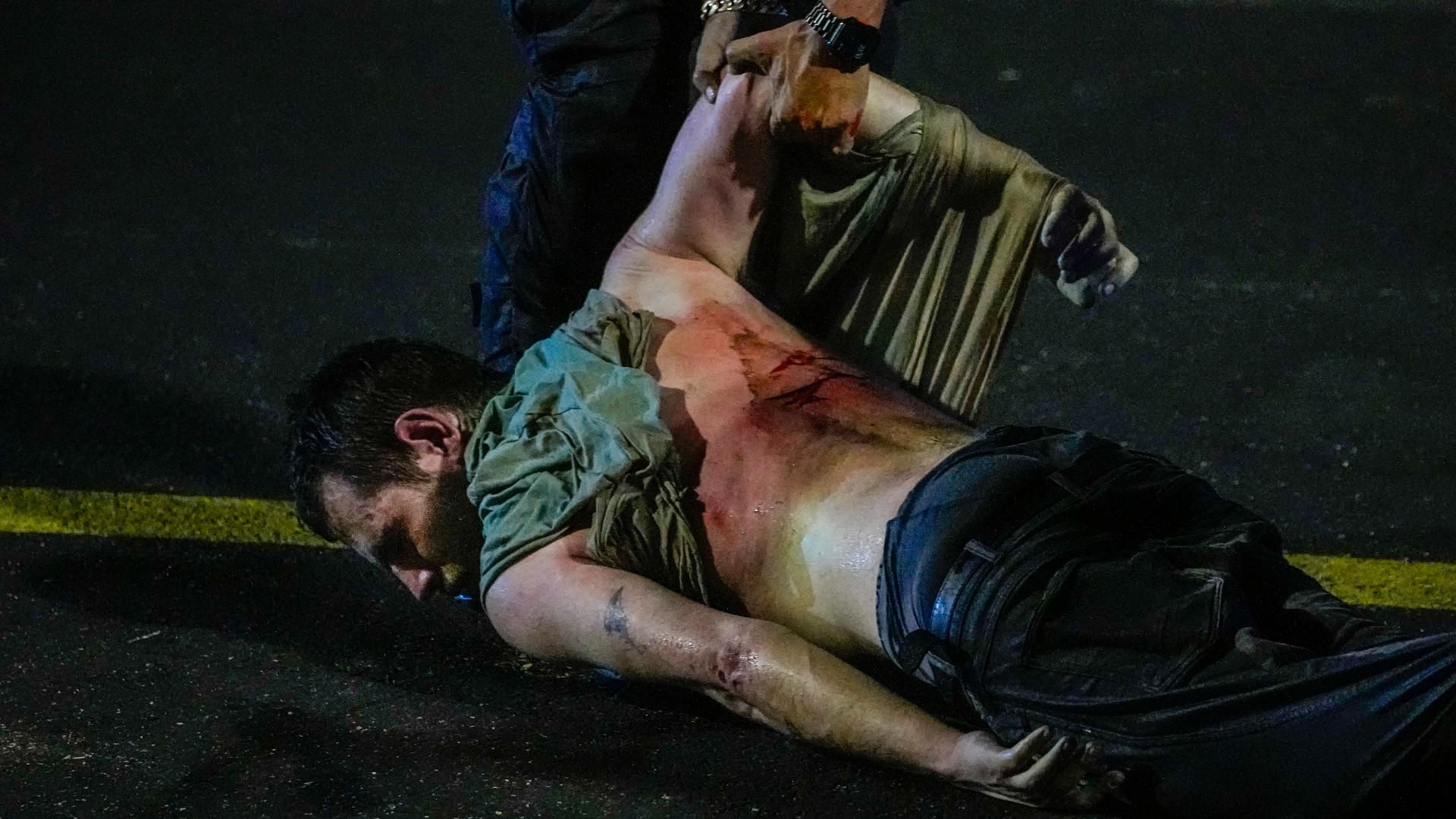 An injured demonstrator is dragged by police to be detained during a protest against plans by Netanyahu's government to overhaul the judicial system, in Tel Aviv, 24 July (AP)