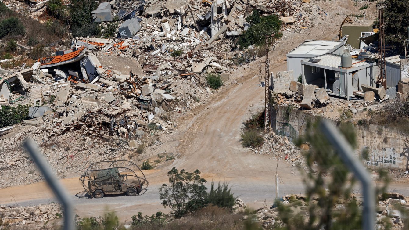 An Israeli military vehicle drives past houses destroyed by Israeli strikes in southern Lebanon, seen from northern Israel, 20 September 2026 (Jalaa Marey/AFP)
