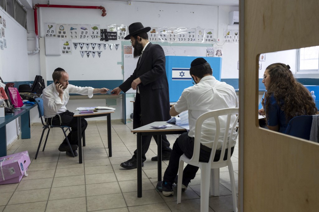 An ultra-Orthodox Jewish man prepares to cast his ballot at a polling station in Bnei Brak on October 27, 2026, during Israel's legislative election