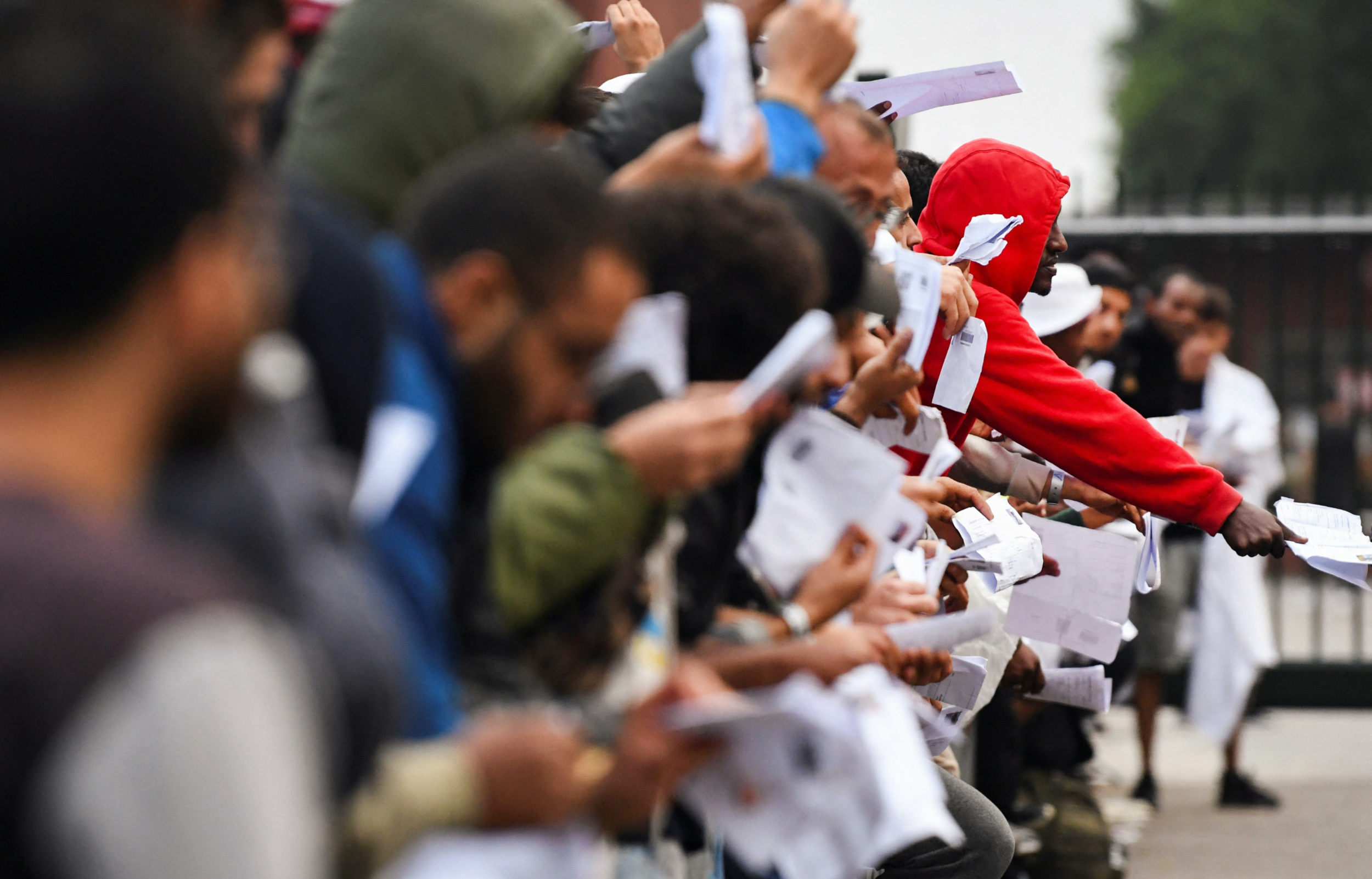 Refugees show their papers at the main reception centre for asylum seekers, in Ter Apel, Netherlands 17 August 2022 (Reuters)