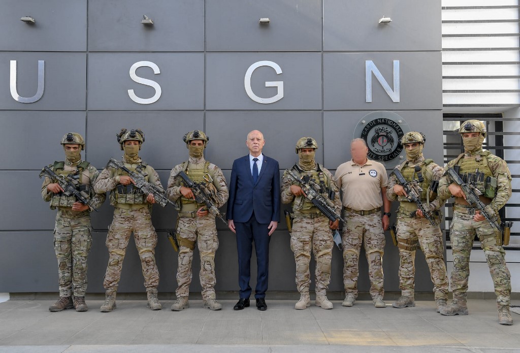 Tunisian President Kais Saied (C) poses with members of the Tunisian National Guard on 4 August 2021, days after he sacked the prime minister and froze parliament (AFP)