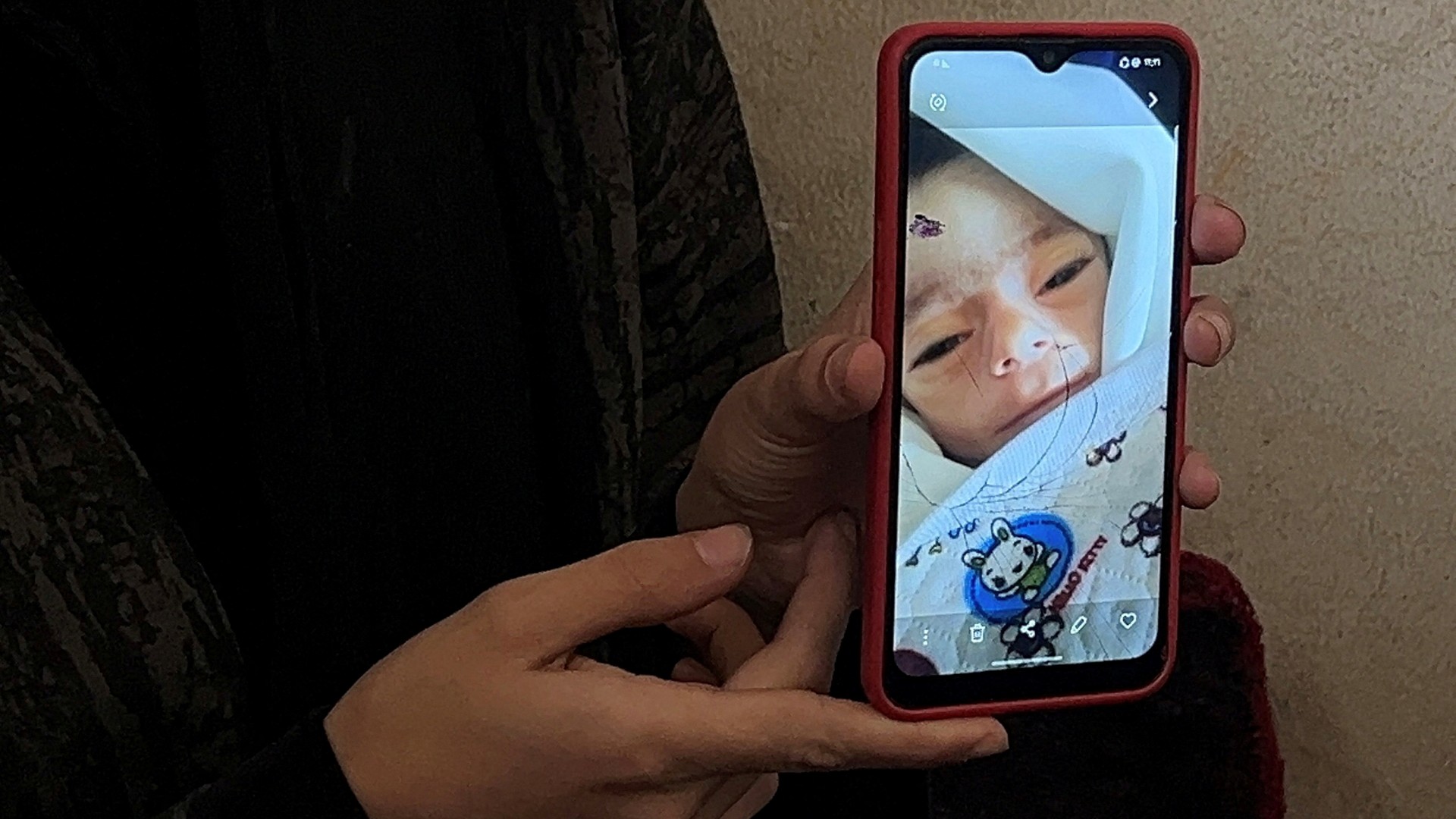 Aya, mother of Palestinian baby Jenan Alskafi, shows a photo on a mobile phone of her daughter who died from malnutrition and untreated digestive complications due to the ongoing Israeli blockade, in Gaza City, May 3, 2025.
