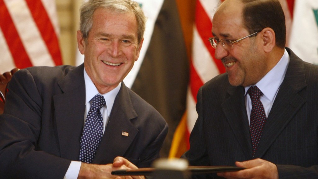 US President George W. Bush (L) and Iraqi Prime Minister Nuri al-Maliki shakes hand after signing an official documents during a joint press conference in Baghdad on December 14, 2008 (AFP)