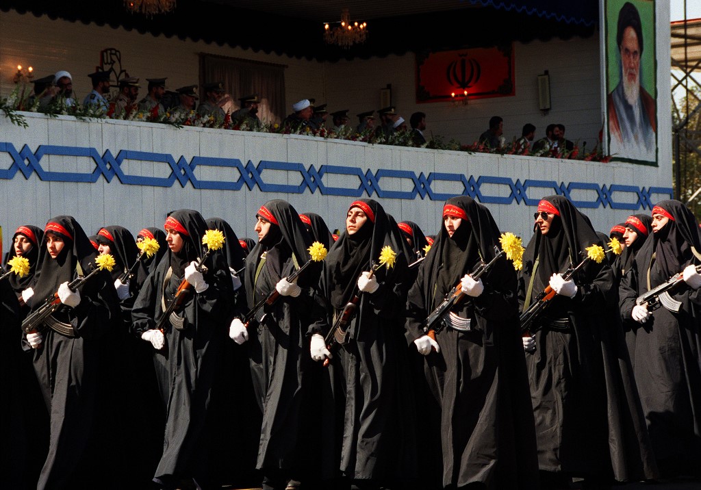 Des membres du Bassidj (« force de mobilisation de la résistance ») défilent devant le président Achemi-Rafsandjani et des responsables militaires iraniens lors des célébrations marquant le 15e anniversaire du début de la guerre Iran-Irak (AFP)