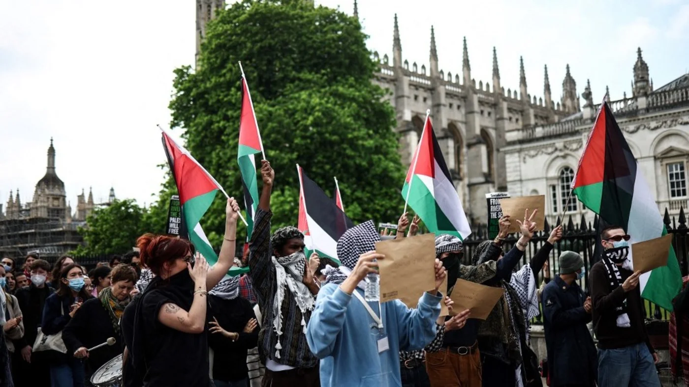 Students wave Palestinian flags during a protest in support of Palestinian people at Cambridge University on 7 May 2024 (Henry Nicholls / AFP)