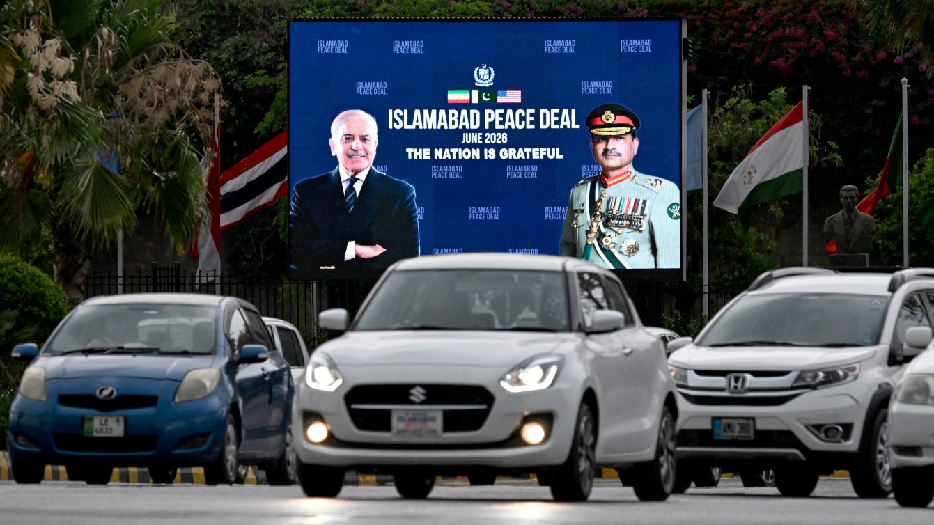 Commuters ride past a billboard featuring Pakistan’s Prime Minister Shehbaz Sharif and Field Marshal Syed Asim Munir in Islamabad following the announcement of the US-Iran peace deal, 17 June 2026 (Aamir Qureshi/AFP)