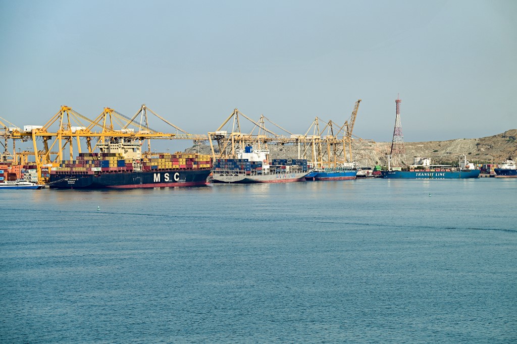 Container vessels and ships are docked along a pier at the Khor Fakkan Container Terminal, the only natural deep-sea port in the region and one of the major container ports in Sharjah Emirate, along the Gulf of Oman on 19 June 2026. (AFP)