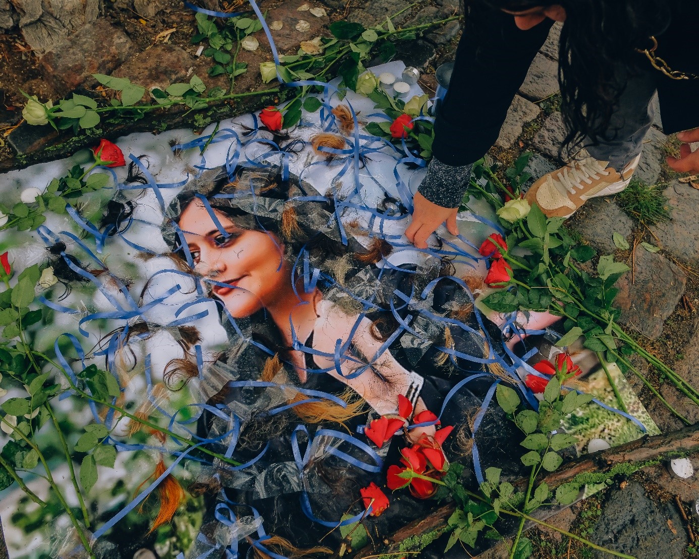Protestors cut their hair and put it on top of a photo of Jina during one of the protests in Copenhagen in September (MEE/Bradley Waller)
