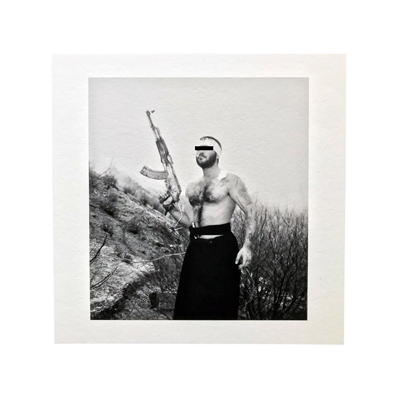 A gangster pictured in unknown whereabouts holding up an AK-47, with scars on his arms from knife fights. (Pouria Khojastehpay)